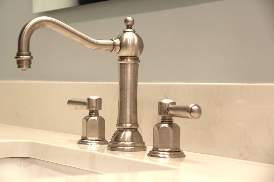 A bathroom sink with a stainless steel faucet