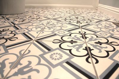 A black and white tile floor with a floral pattern.