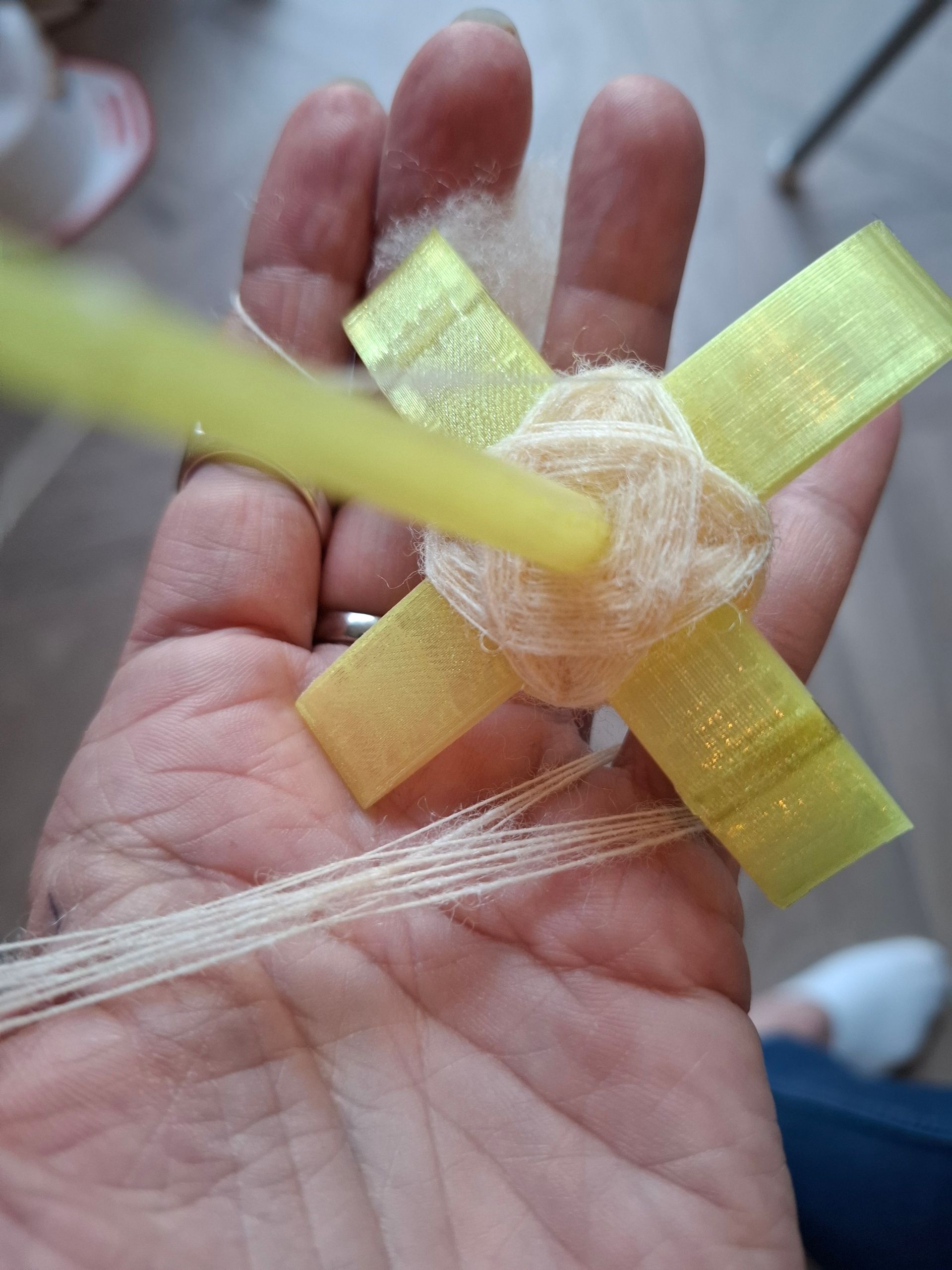 Gele kruisspintol met fijne wol.