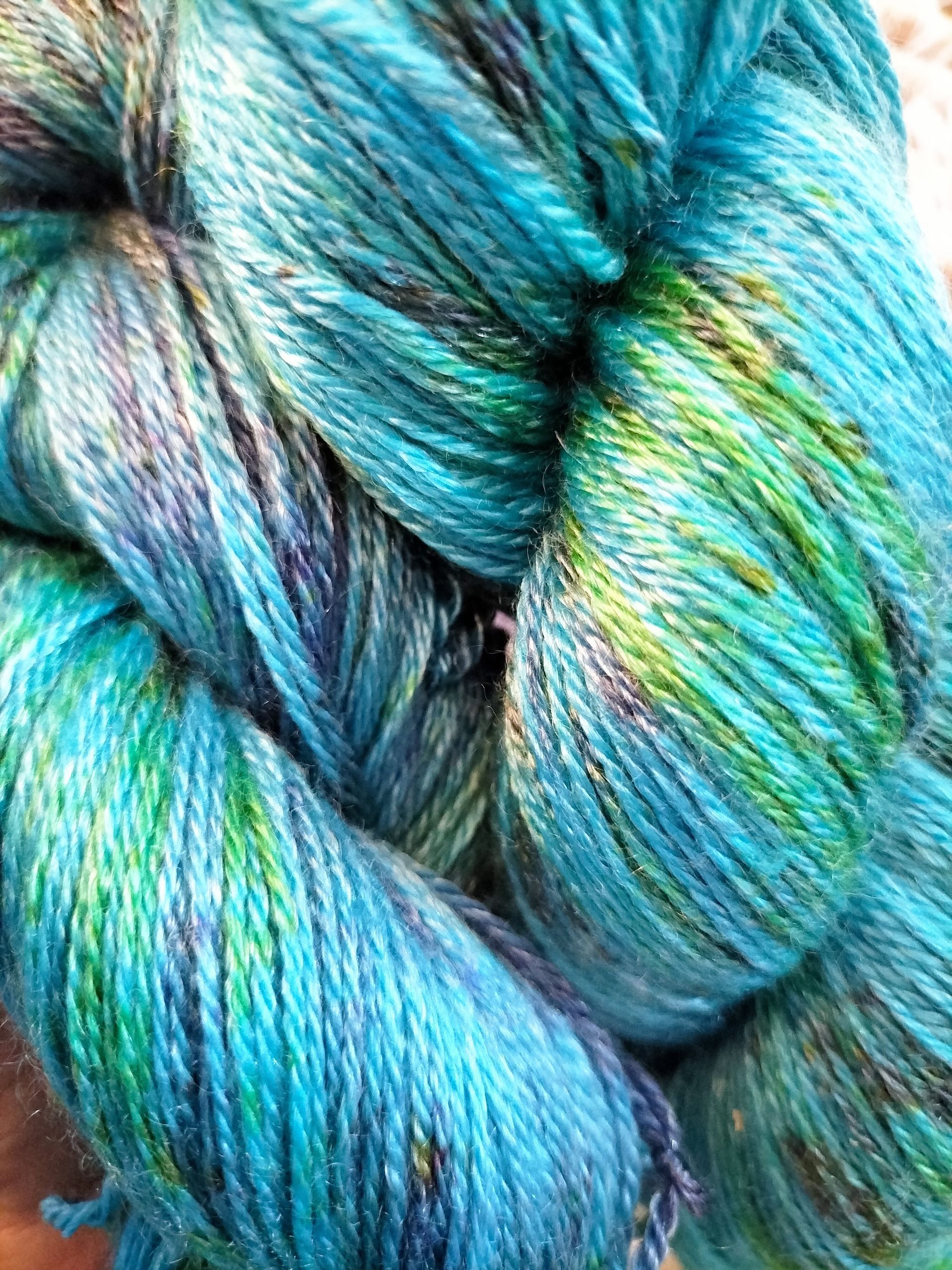 Close-up van een streng handgeverfd blauwgroen garen.