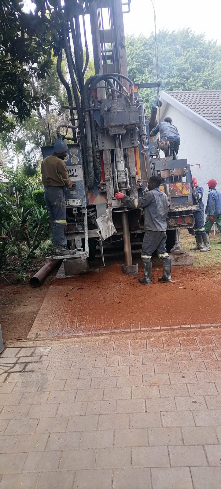 A group of construction workers are working on a large pipe.