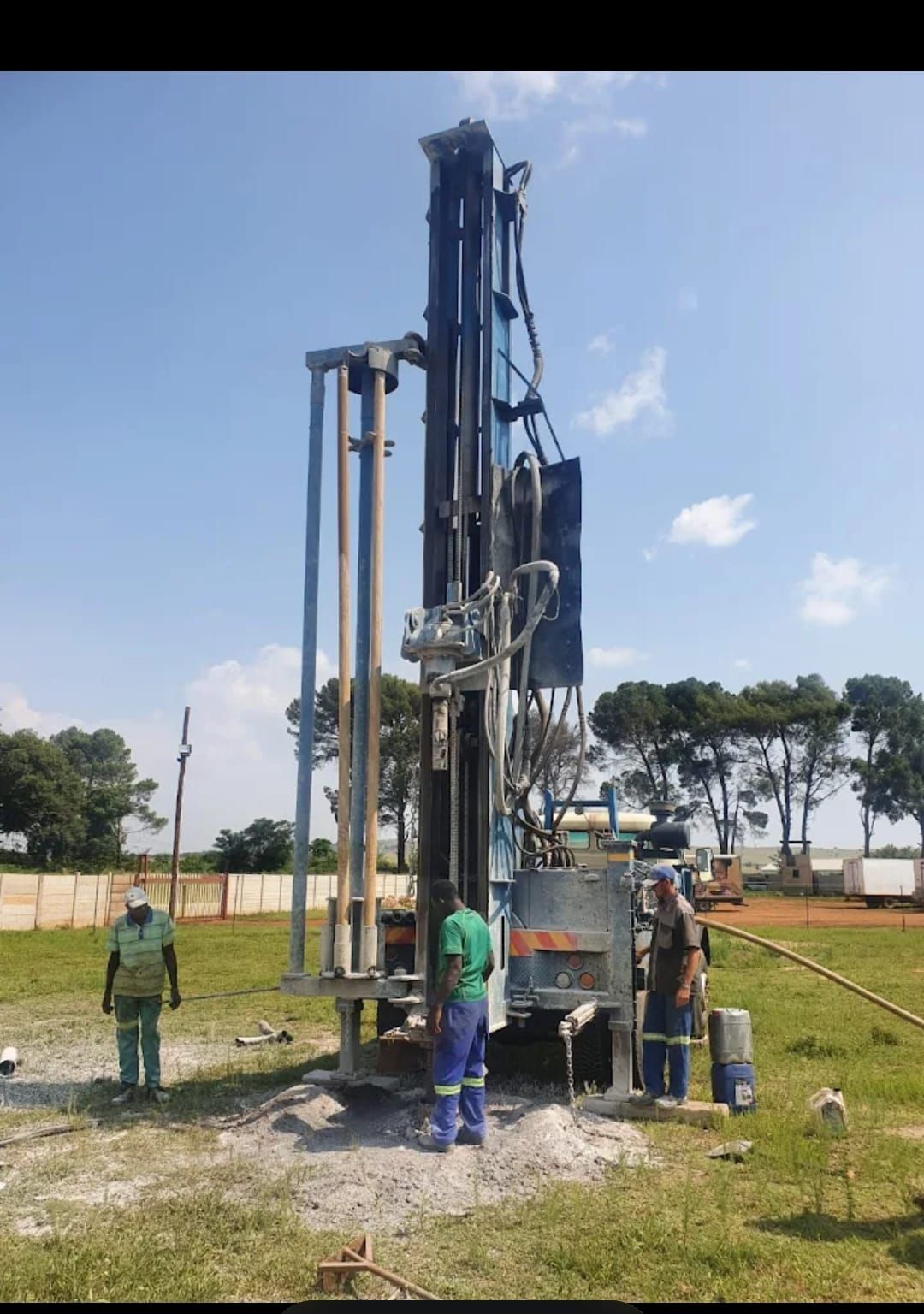 A group of construction workers are working on a large pipe.