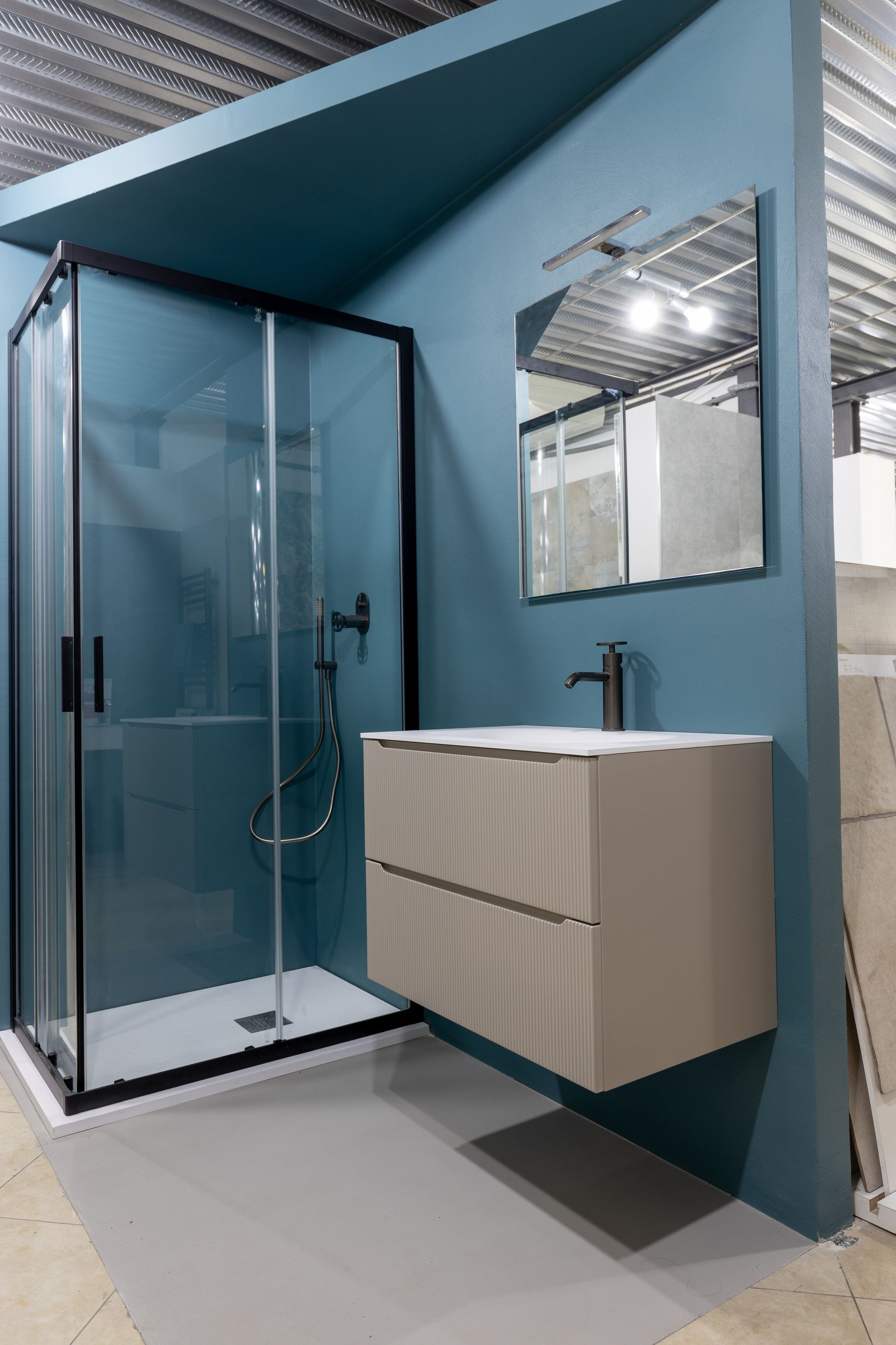 Bagno moderno con pareti color verde acqua, doccia, mobile lavabo e specchio.