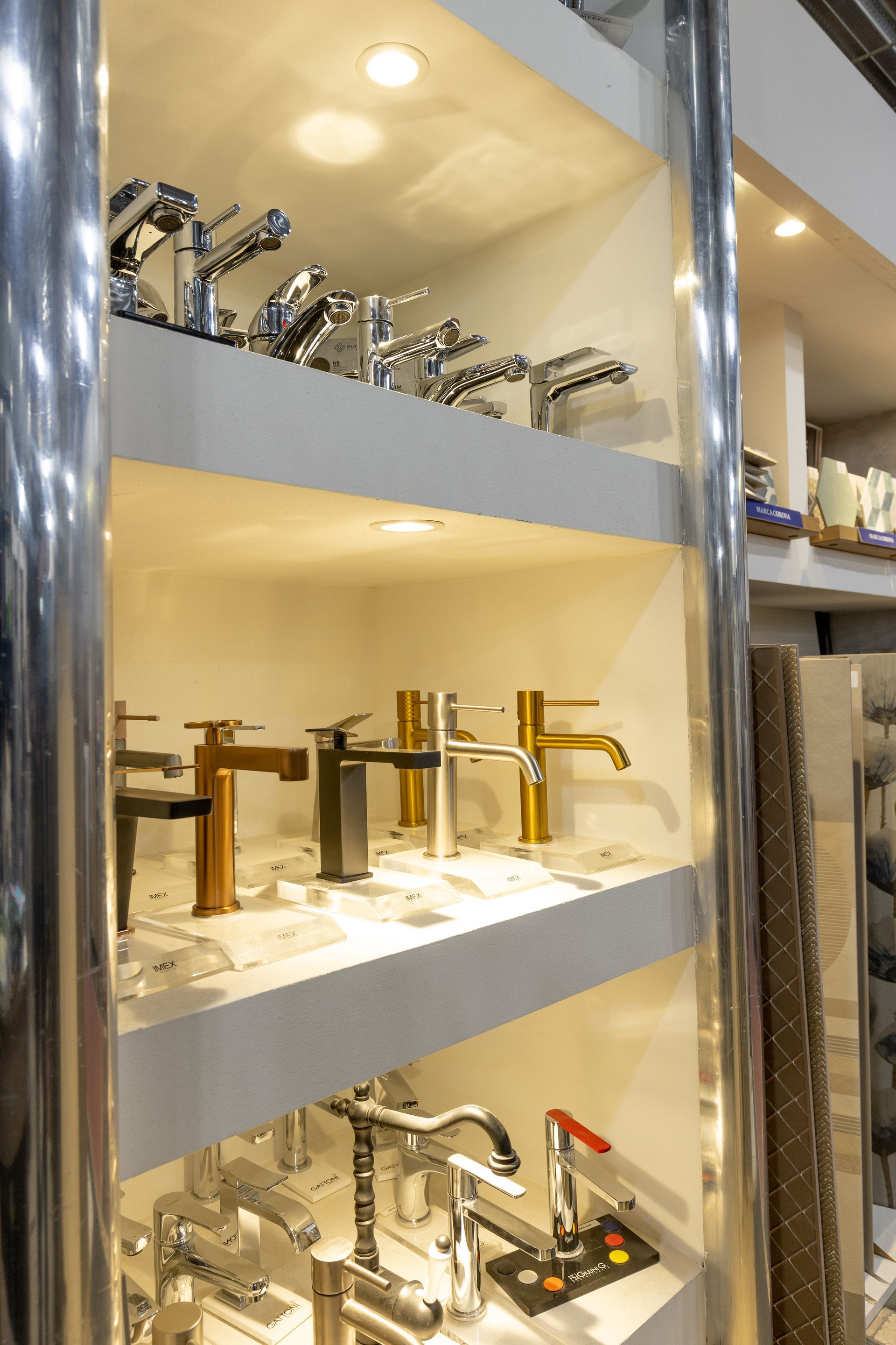 Scaffali che espongono vari rubinetti per il bagno in un negozio di ferramenta, con finiture in argento e oro.