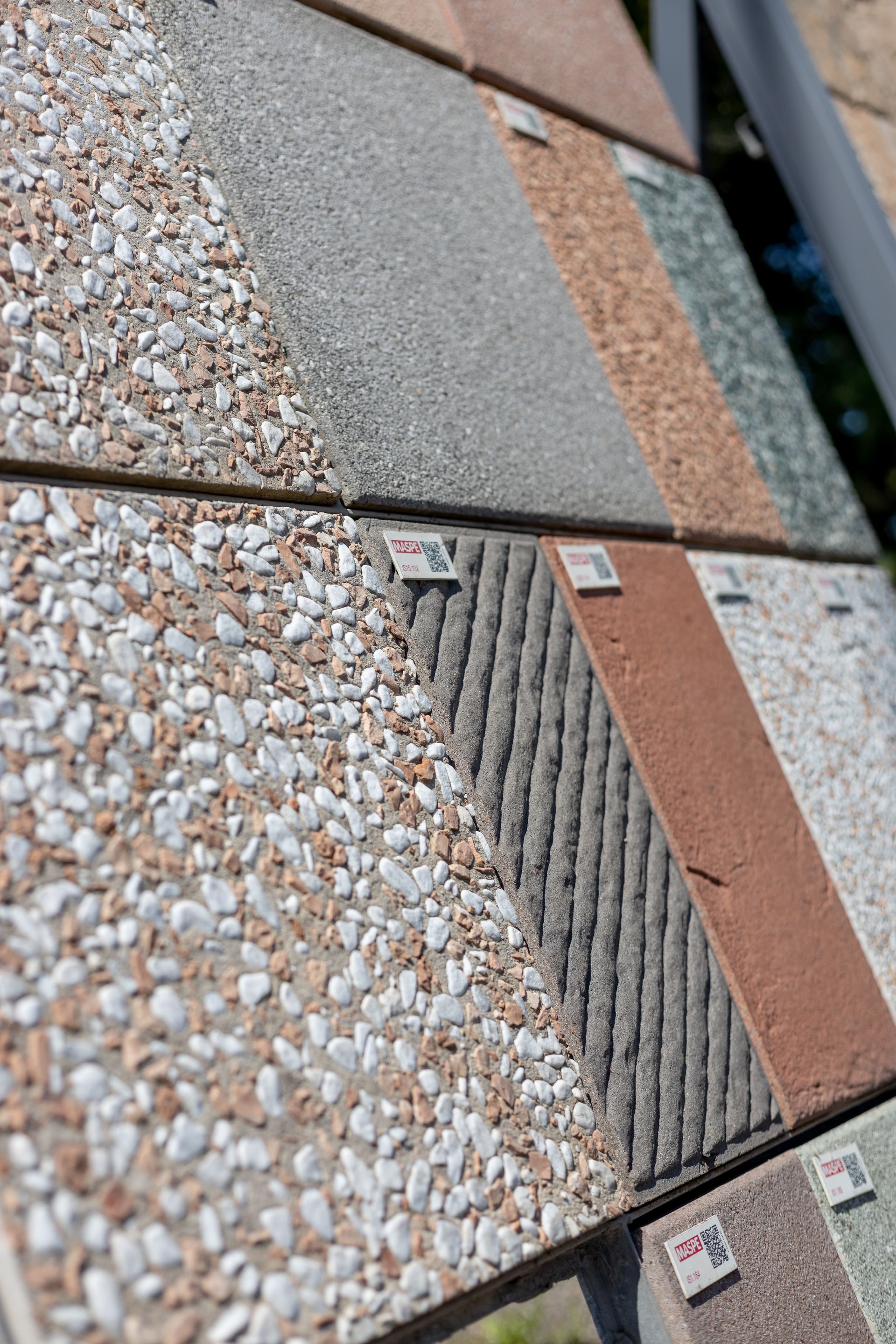 Esposizione di vari campioni di pietre per pavimentazione testurizzate.