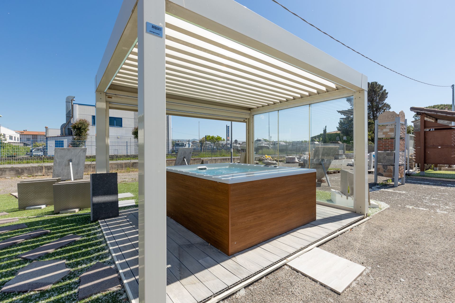 Vasca idromassaggio sotto un pergolato bianco in una giornata di sole.