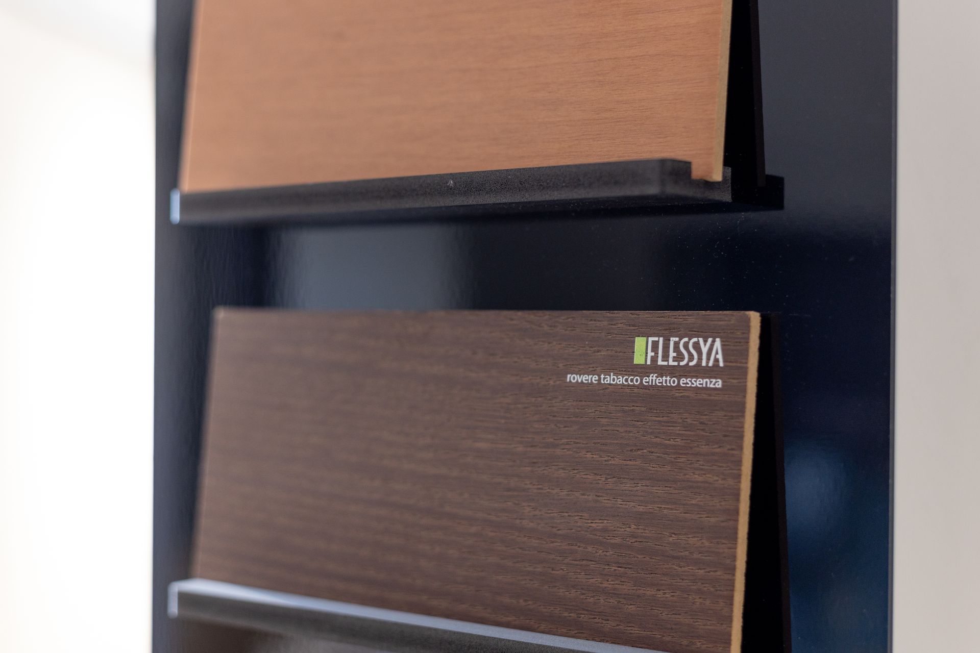 Due campioni di legno montati su un espositore, uno marrone e uno marrone scuro, con il marchio