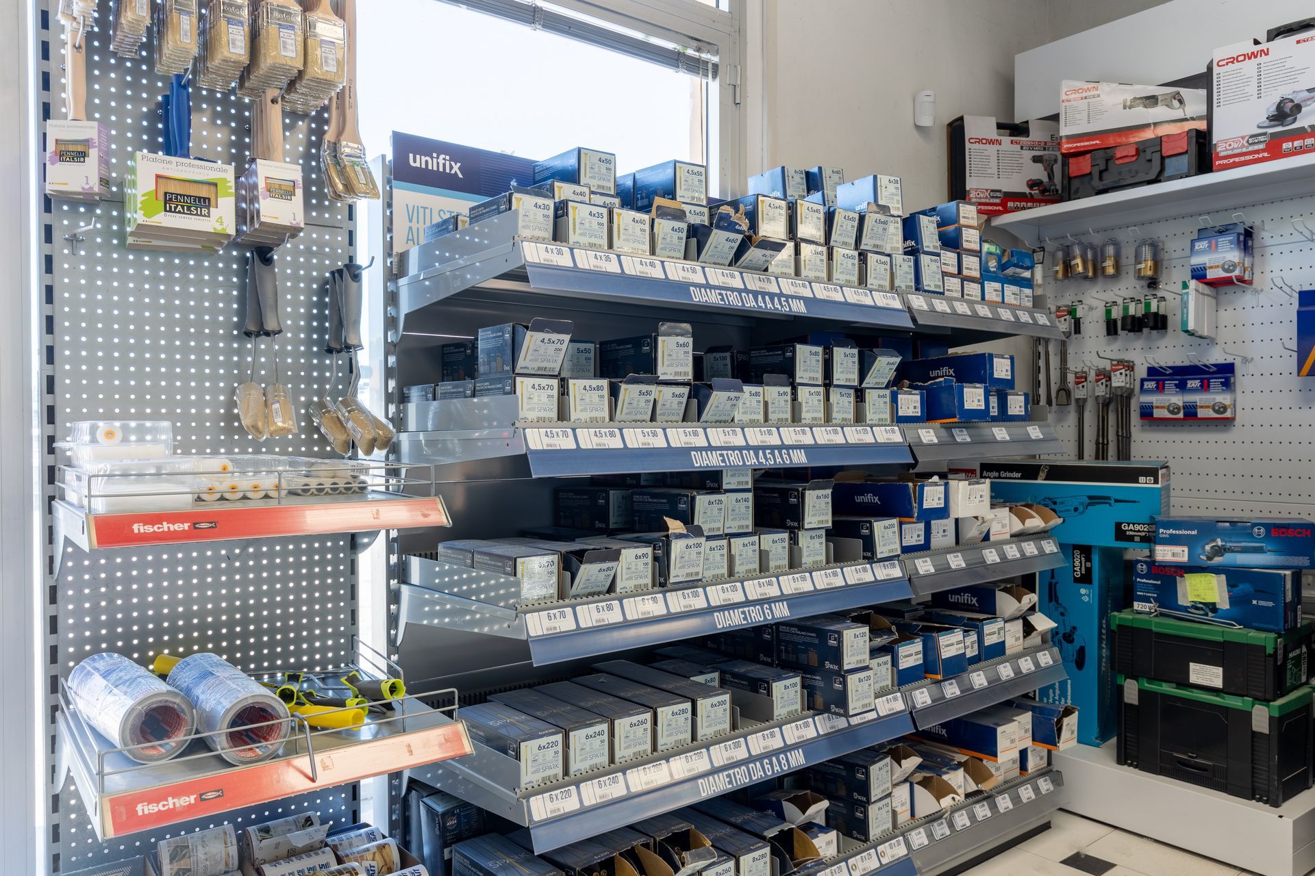 Scaffali di un negozio di autoricambi, riforniti di vari componenti e forniture per auto, illuminazione intensa.