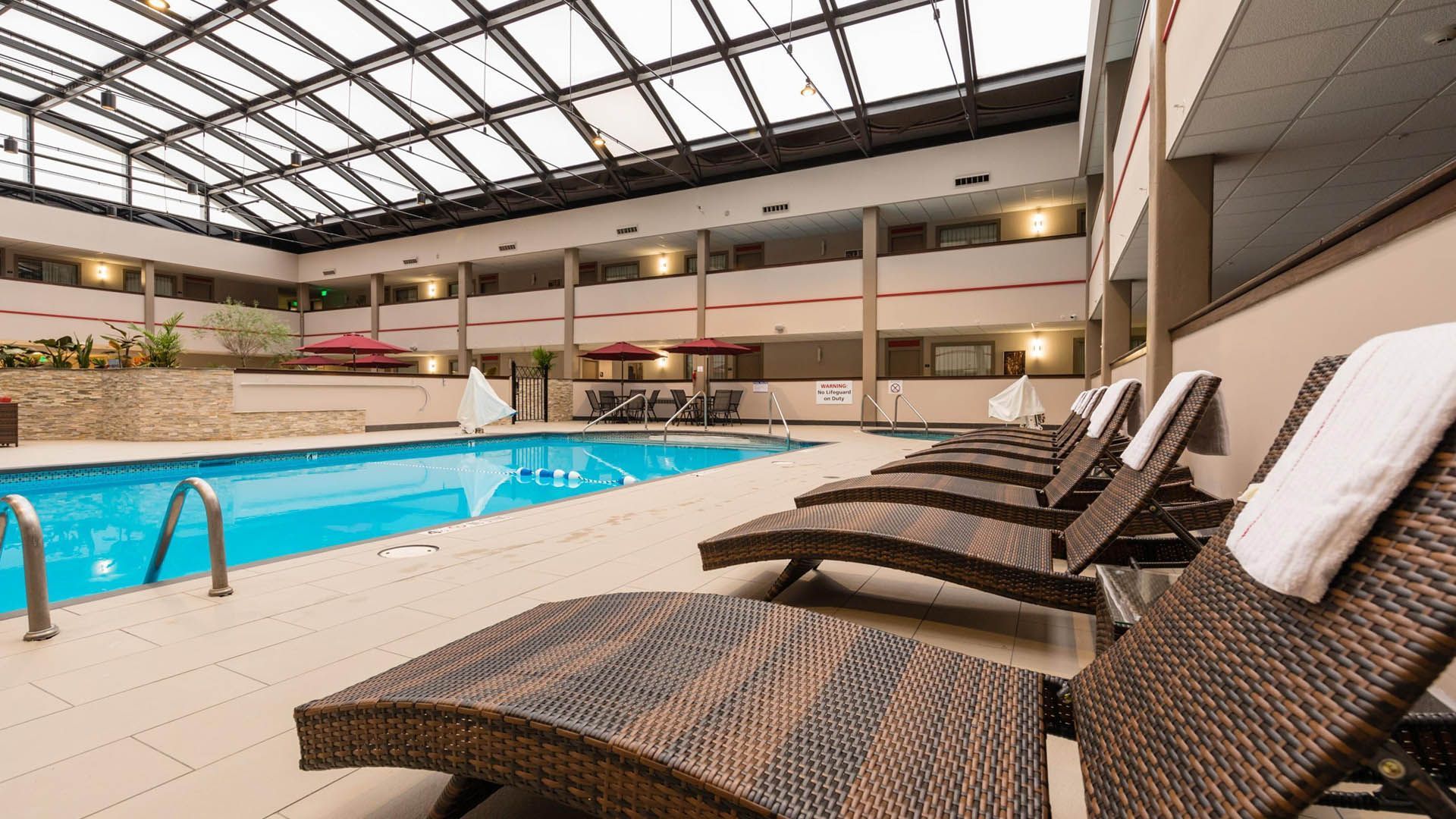 Relax at one of Milwaukee’s best hotel pools during your summer stay. Indoor hotel swimming pool with lounge chairs and a glass roof in Milwaukee.