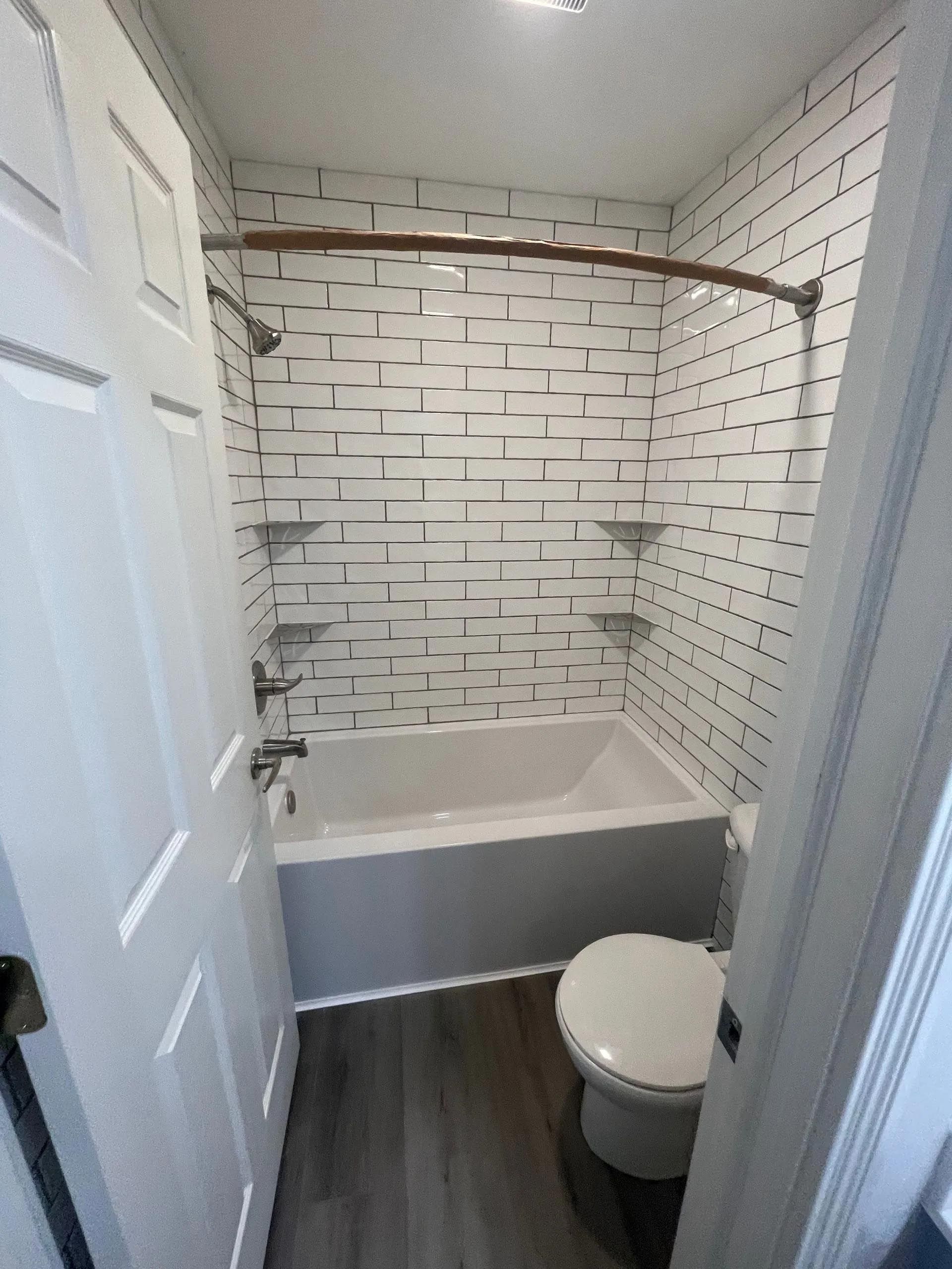A bathroom with a tub , toilet and shower.