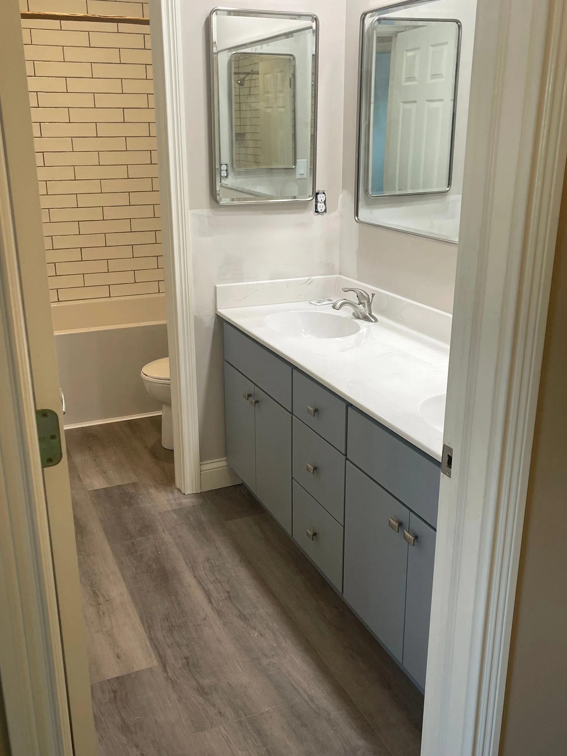 A bathroom with a sink , mirrors and a toilet.