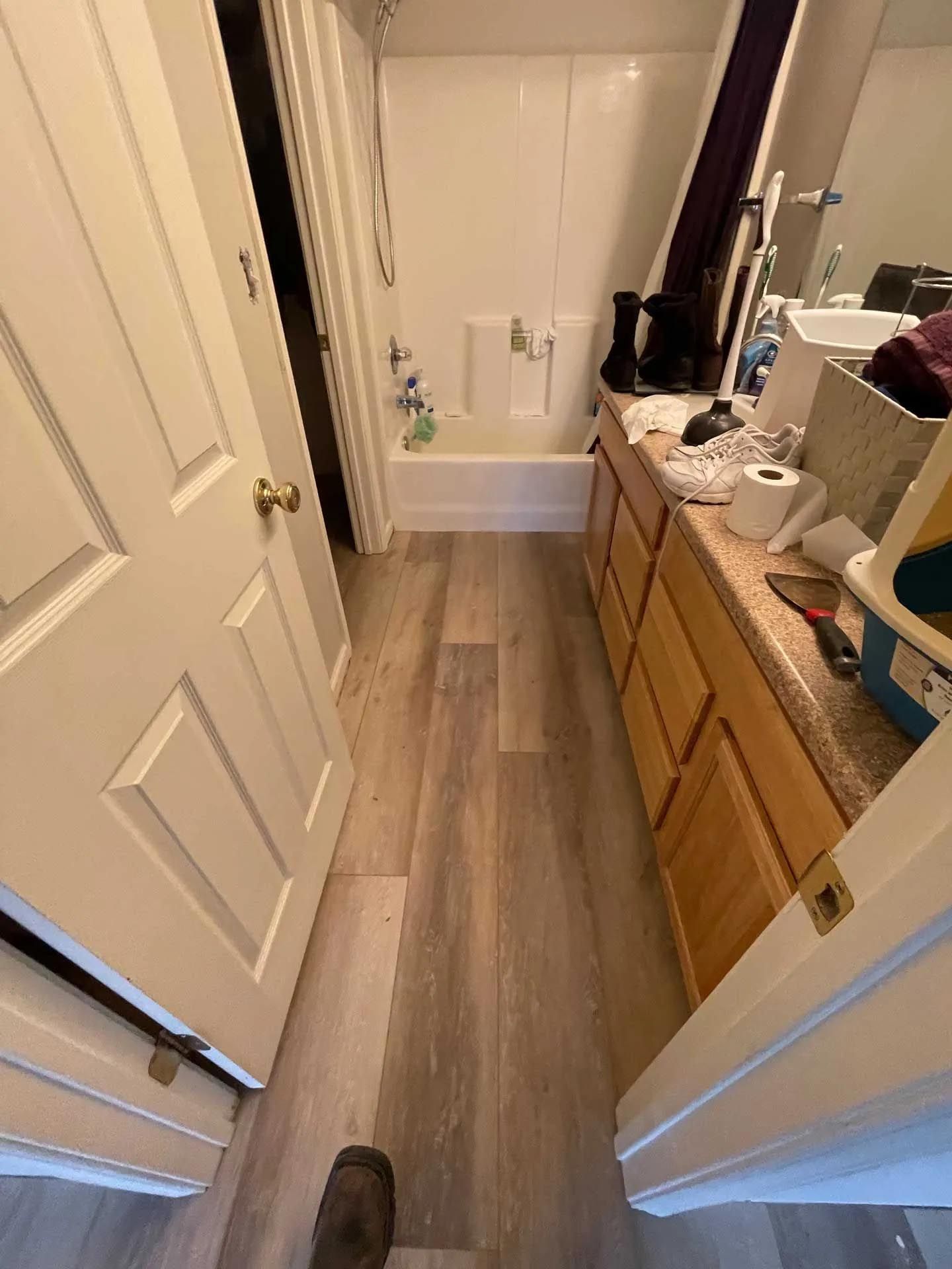 A bathroom with a bathtub , sink , and mirror.