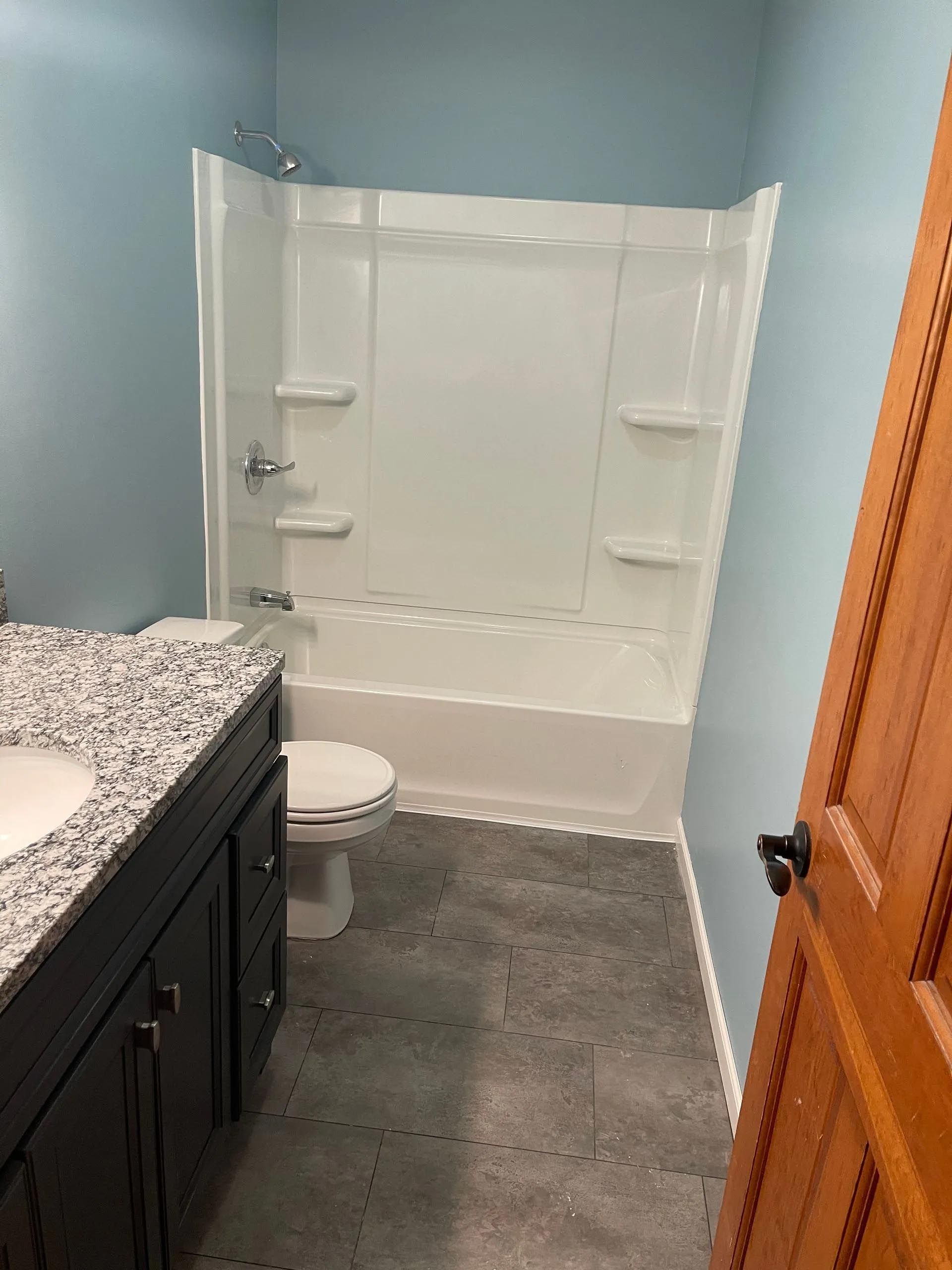A bathroom with a toilet , sink and bathtub.