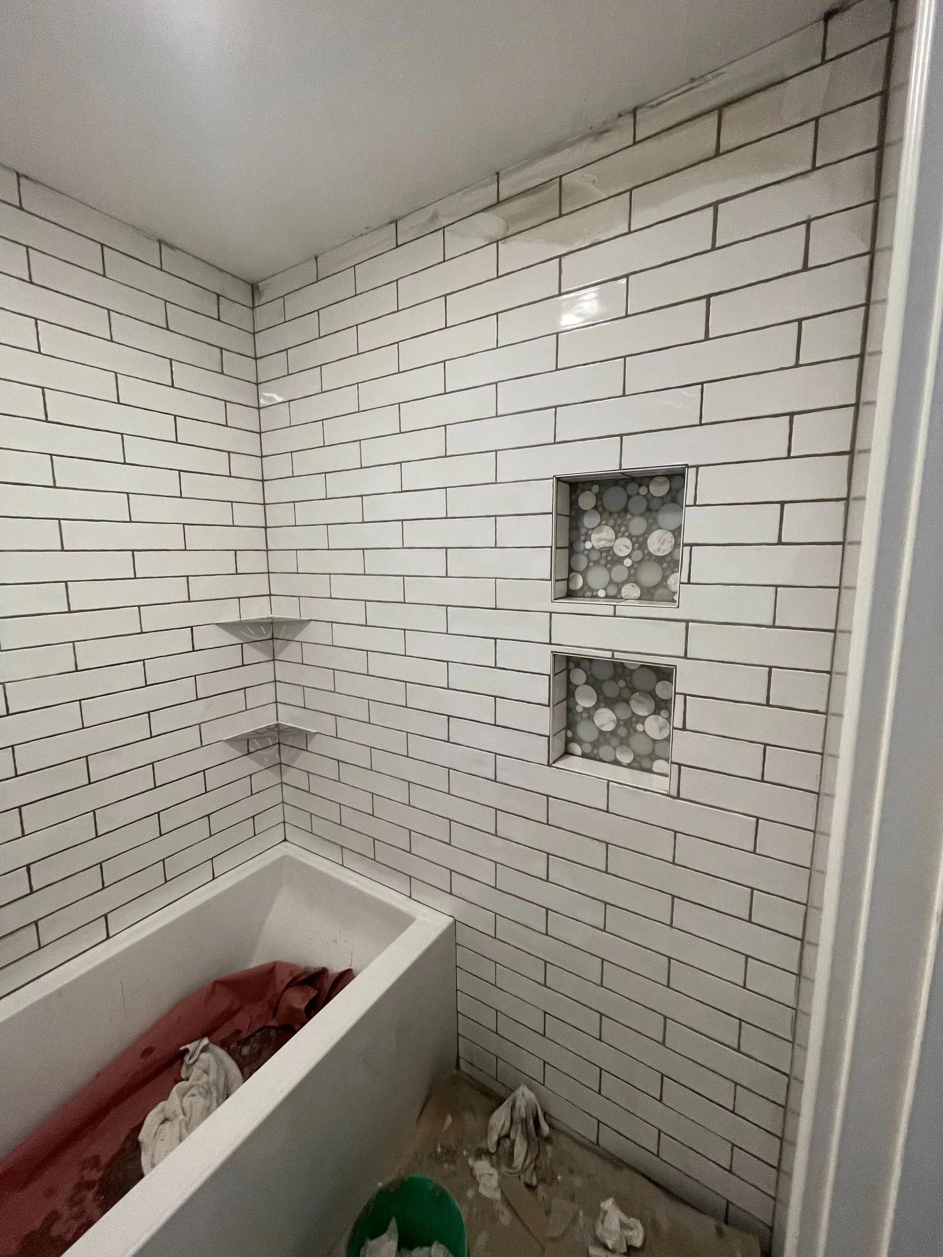 A bathroom with white brick walls and a bathtub