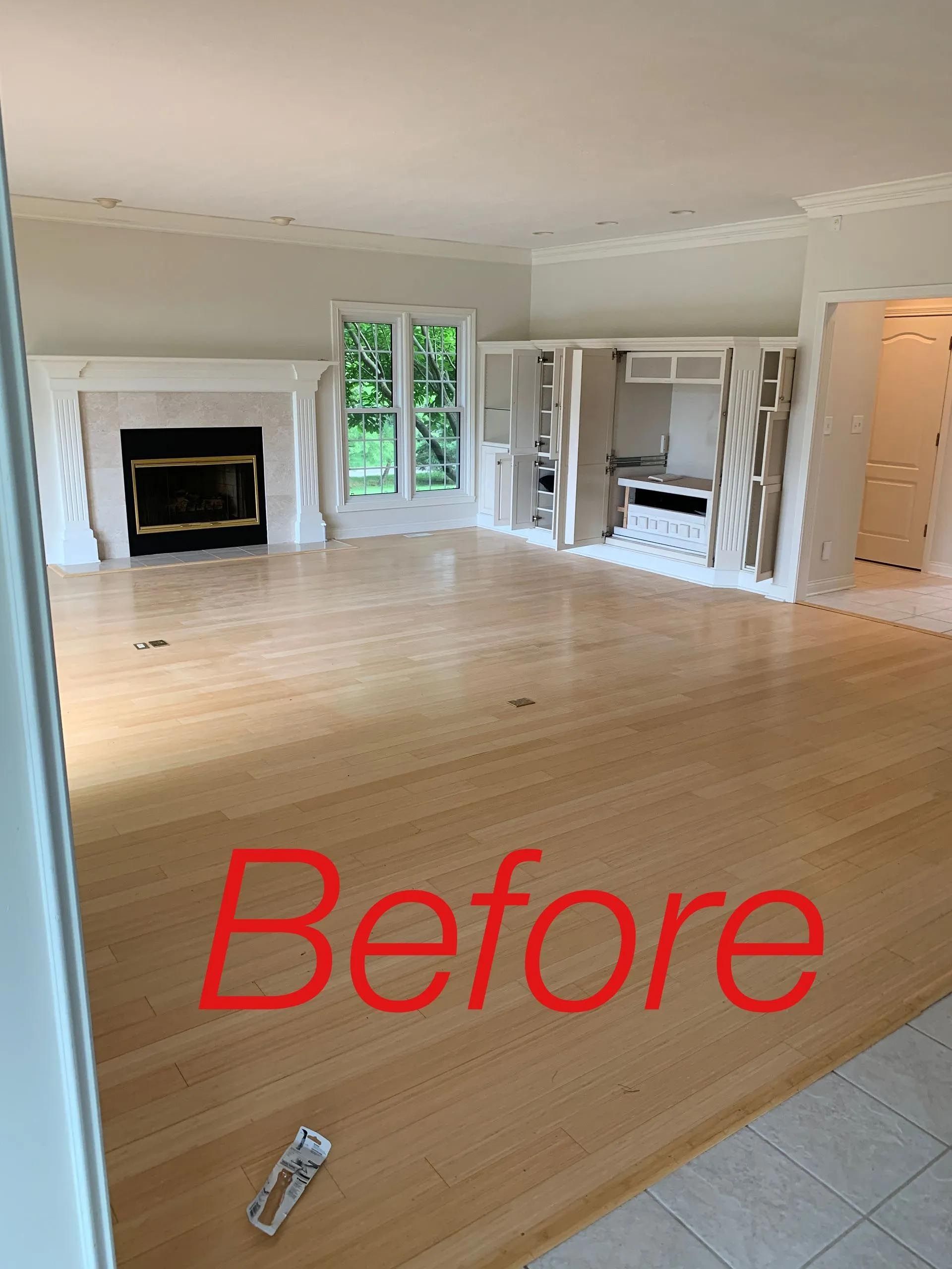 An empty living room with the word before on the floor