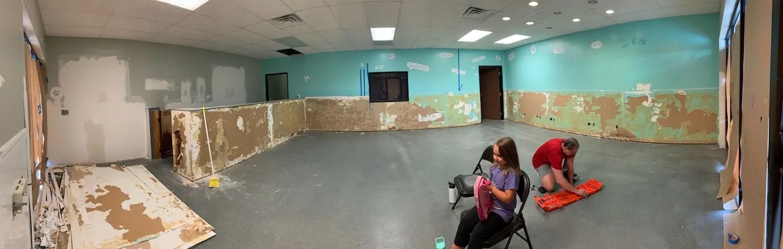 A group of people are working in an empty room.