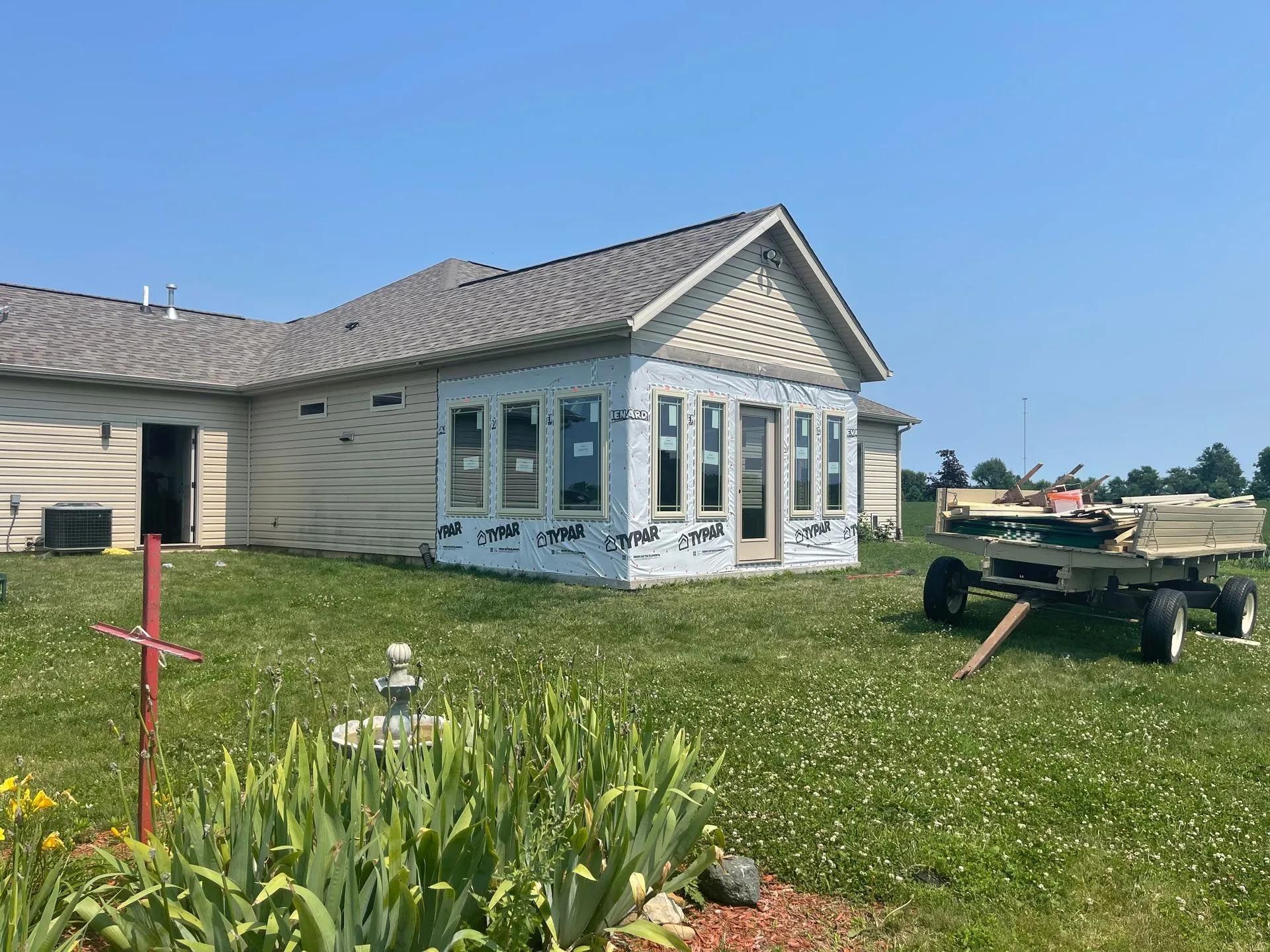 A house is being built in the middle of a grassy field.
