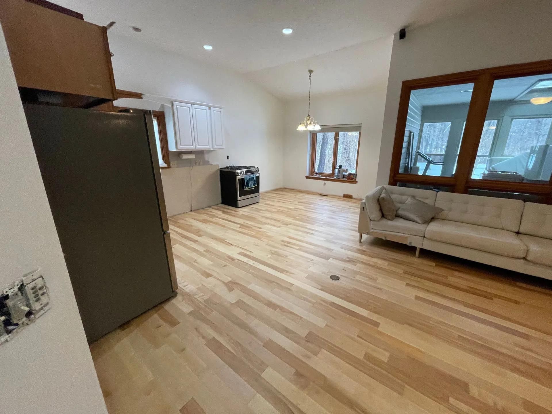 A living room with hardwood floors and a couch.