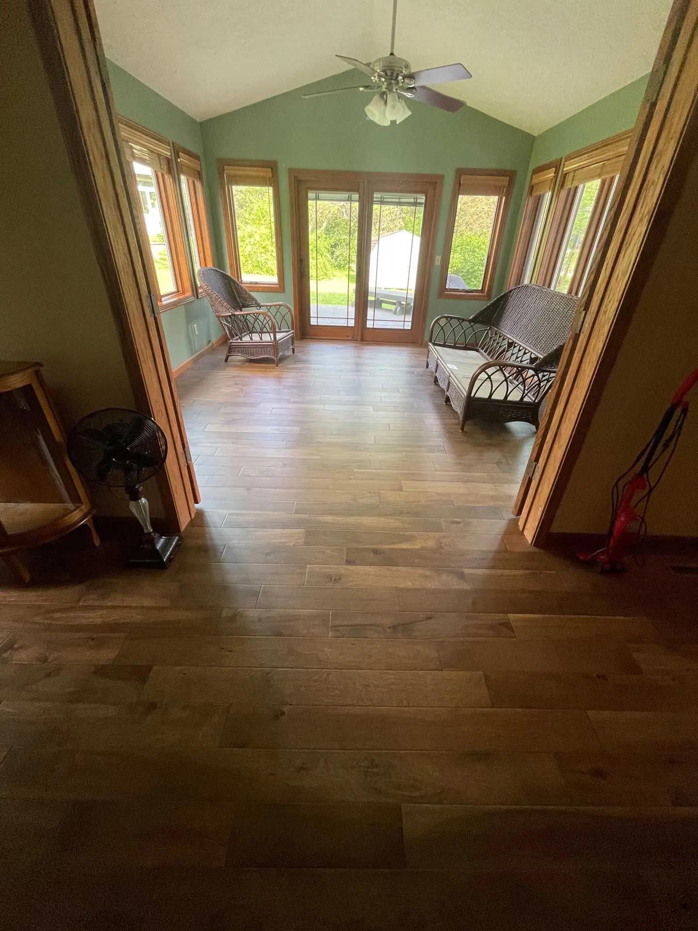 A living room with hardwood floors and a ceiling fan.