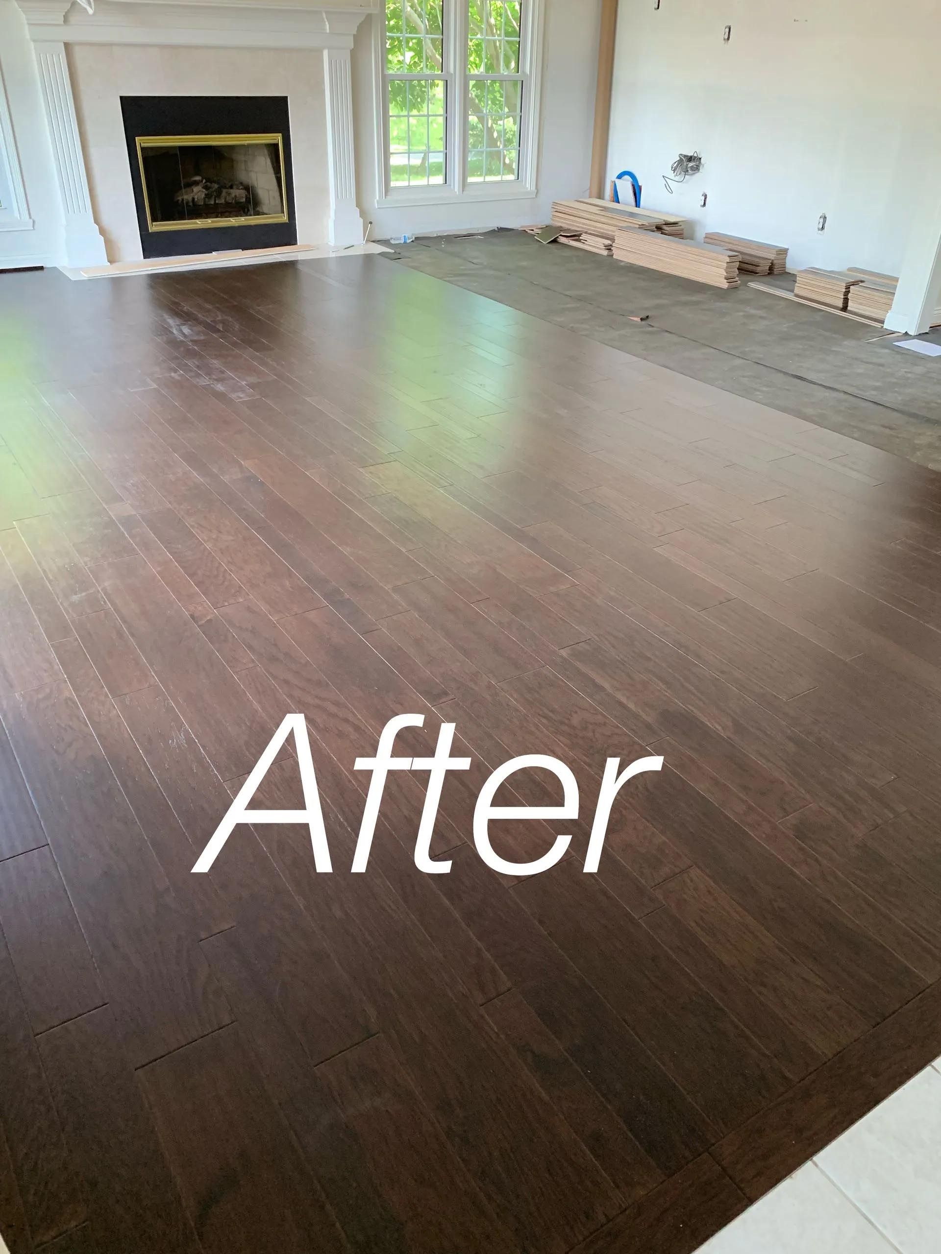 A living room with a wooden floor and a fireplace.