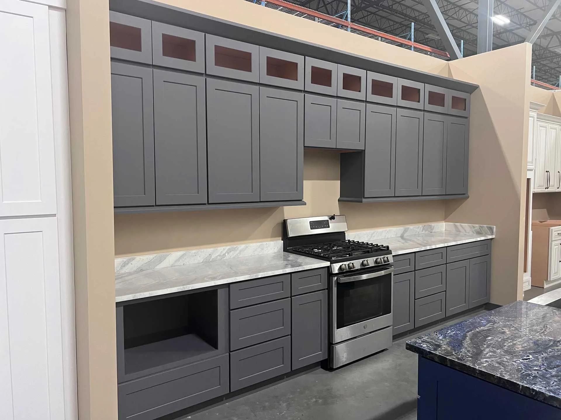 A kitchen with gray cabinets and stainless steel appliances