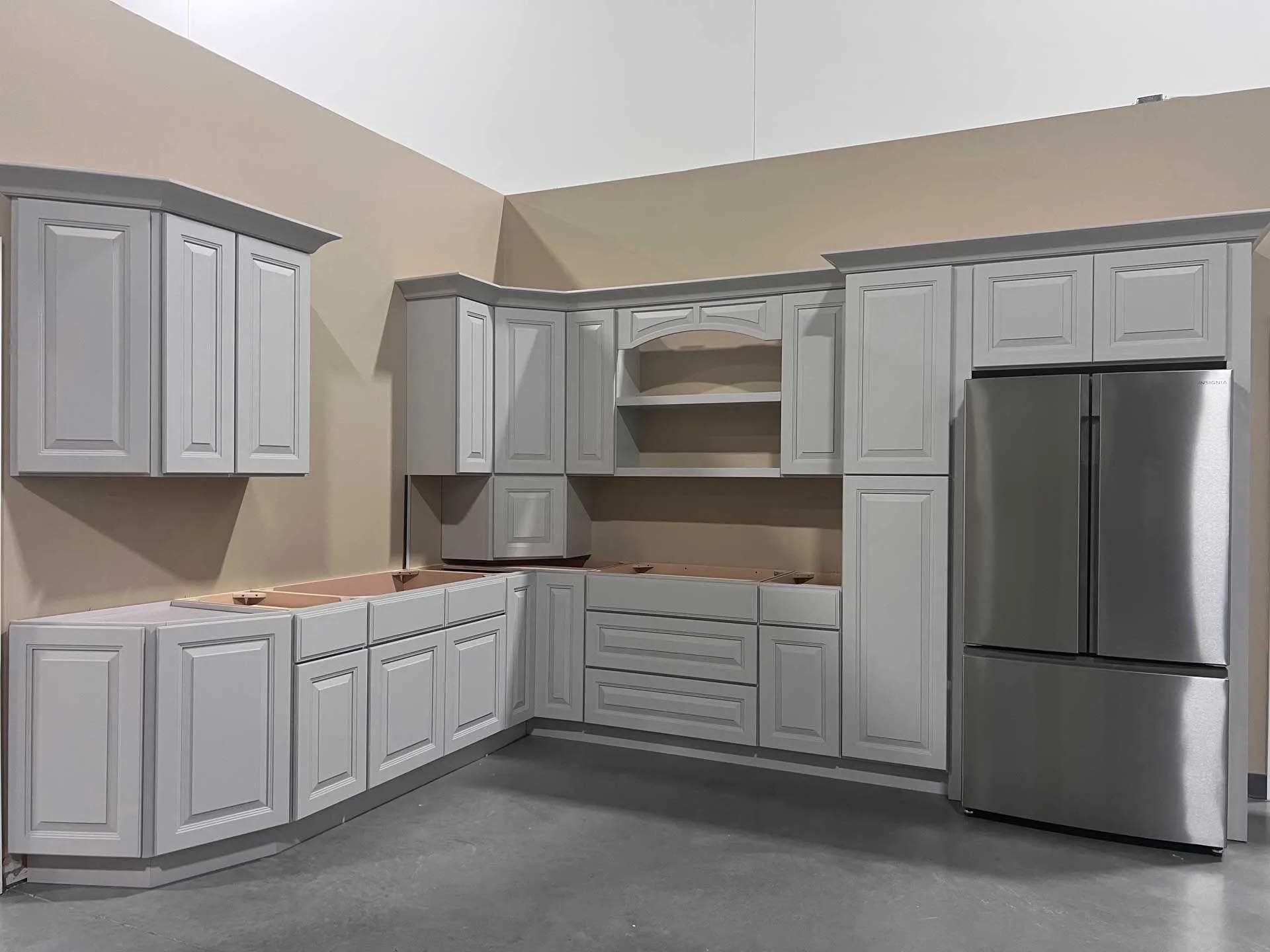 A kitchen with white cabinets and a stainless steel refrigerator.