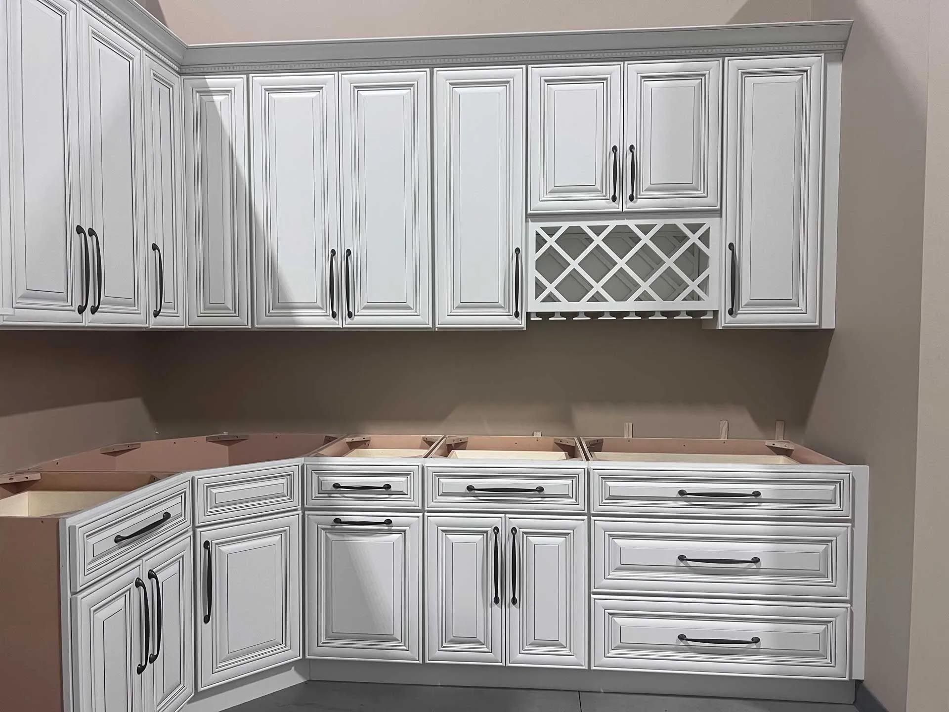 A kitchen with white cabinets and drawers and a sink.