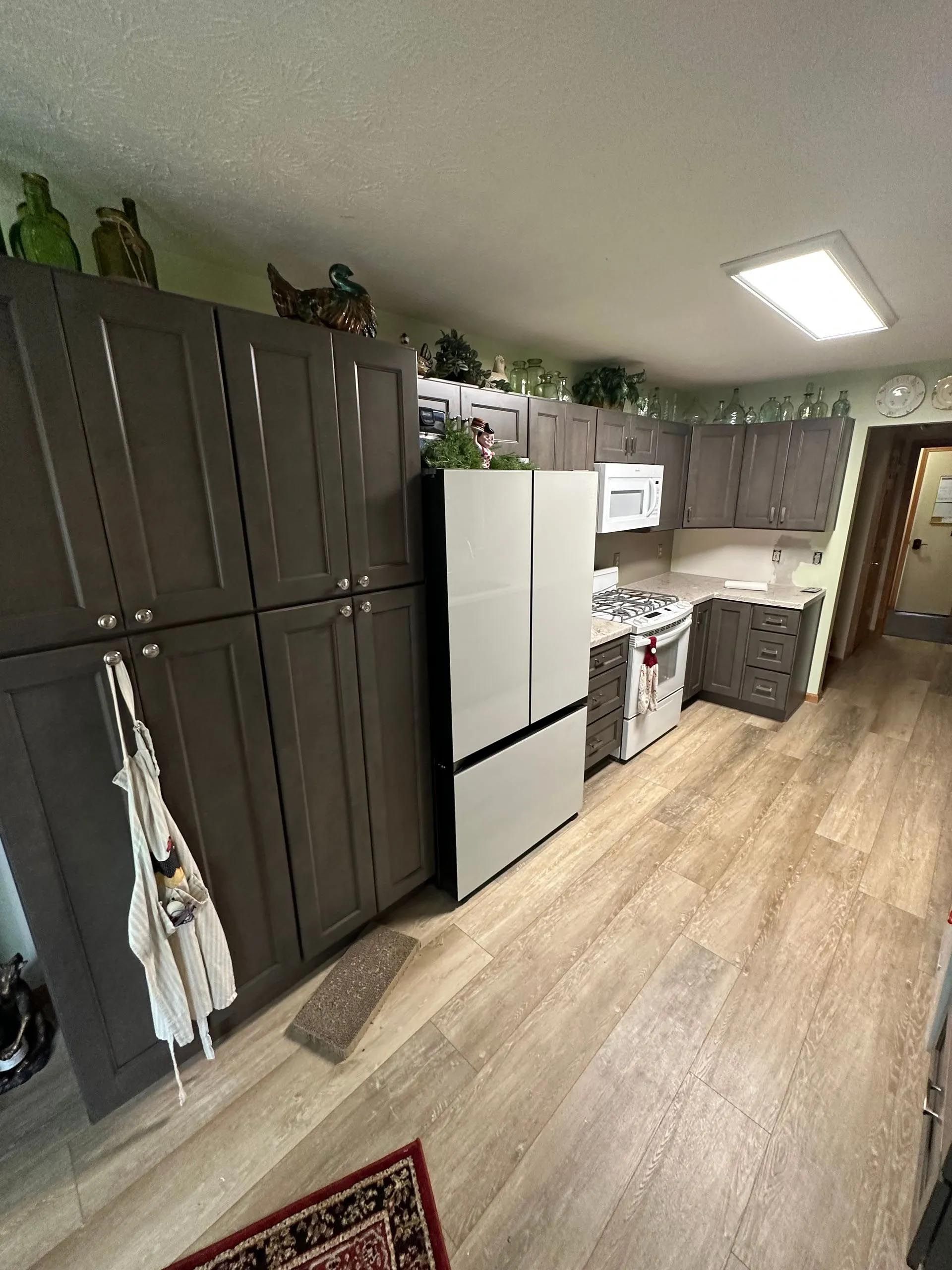 A kitchen with a refrigerator , stove , microwave and cabinets.