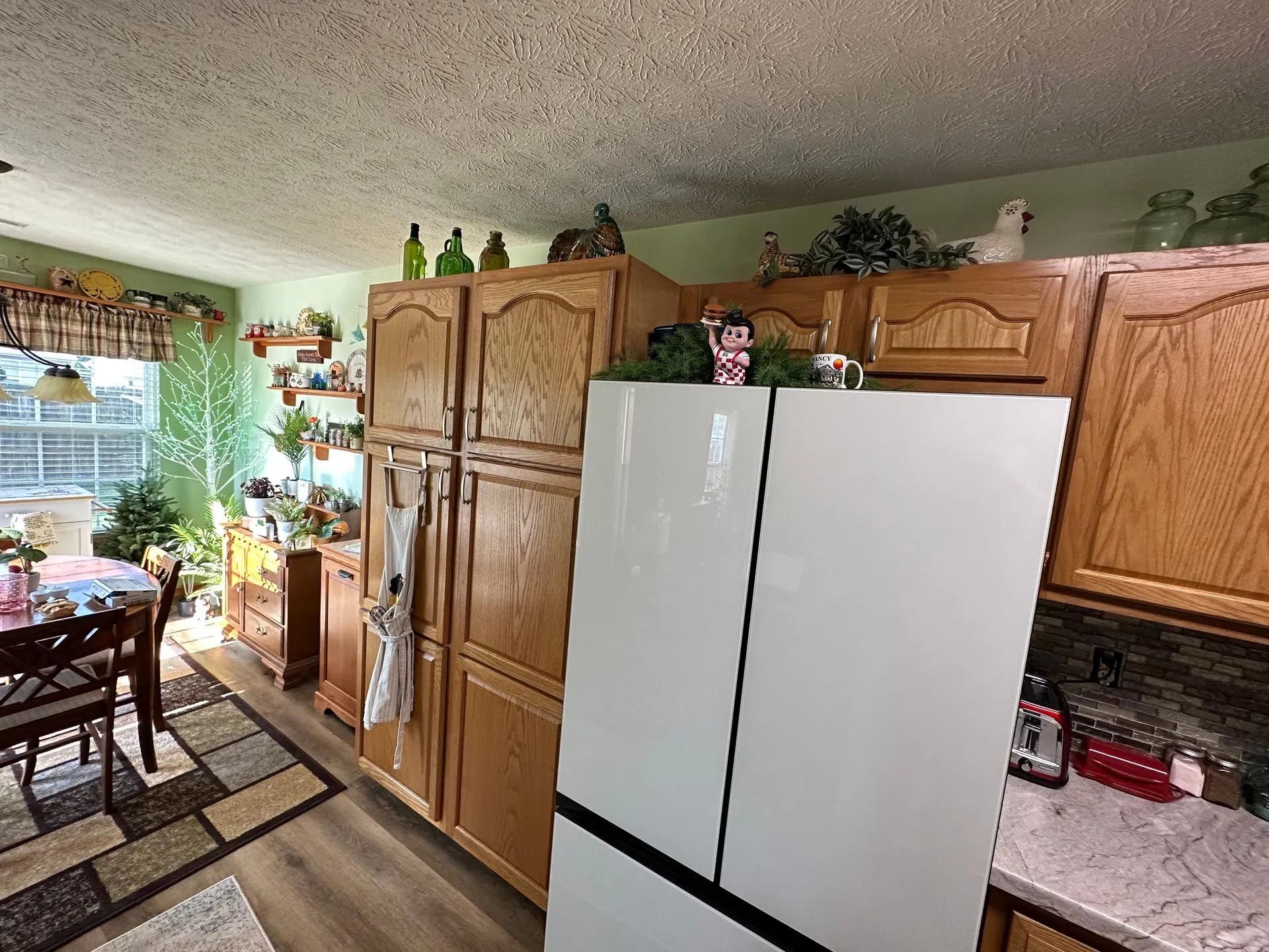 A kitchen with wooden cabinets and a white refrigerator.