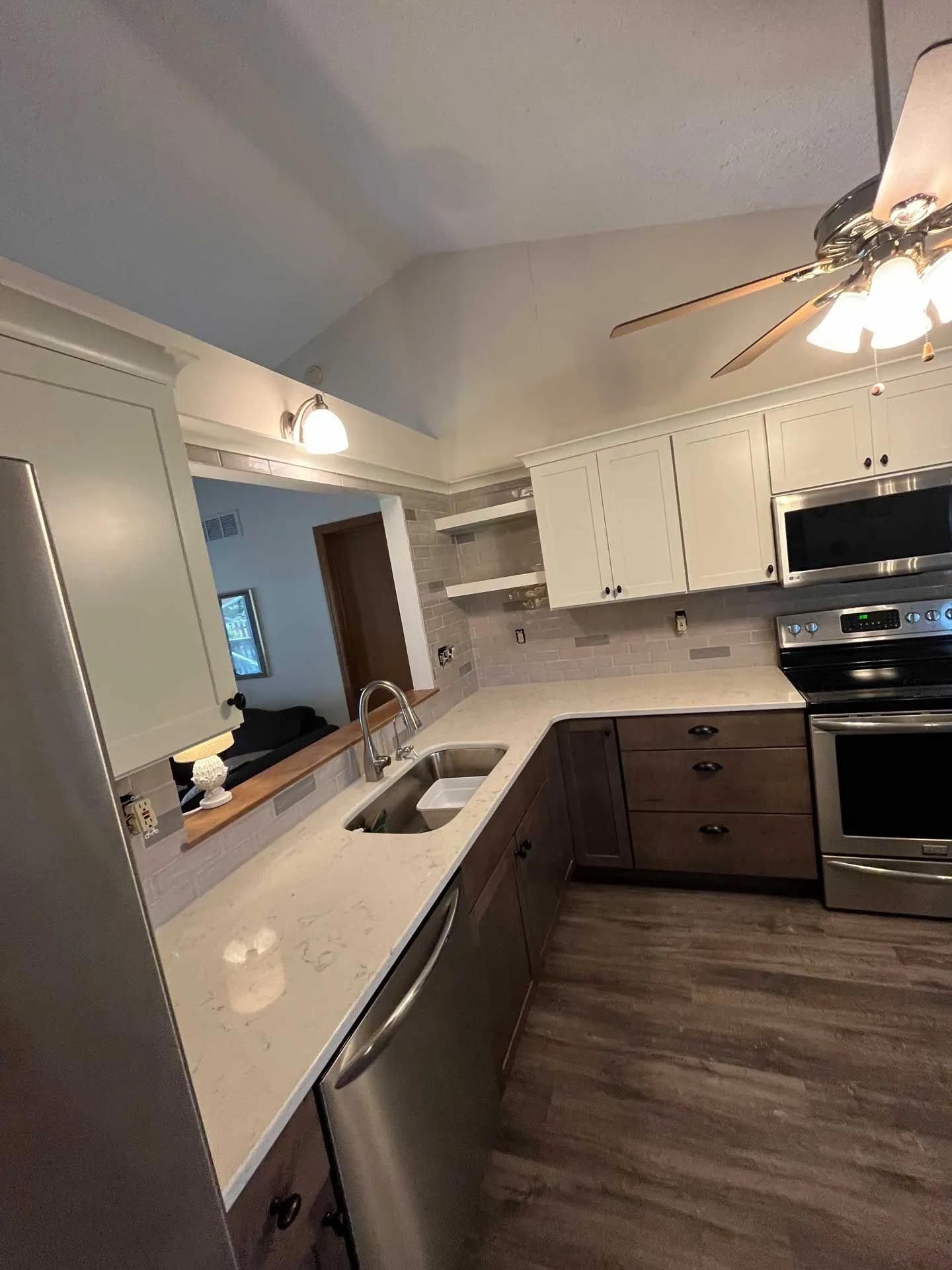 A kitchen with stainless steel appliances and a ceiling fan.