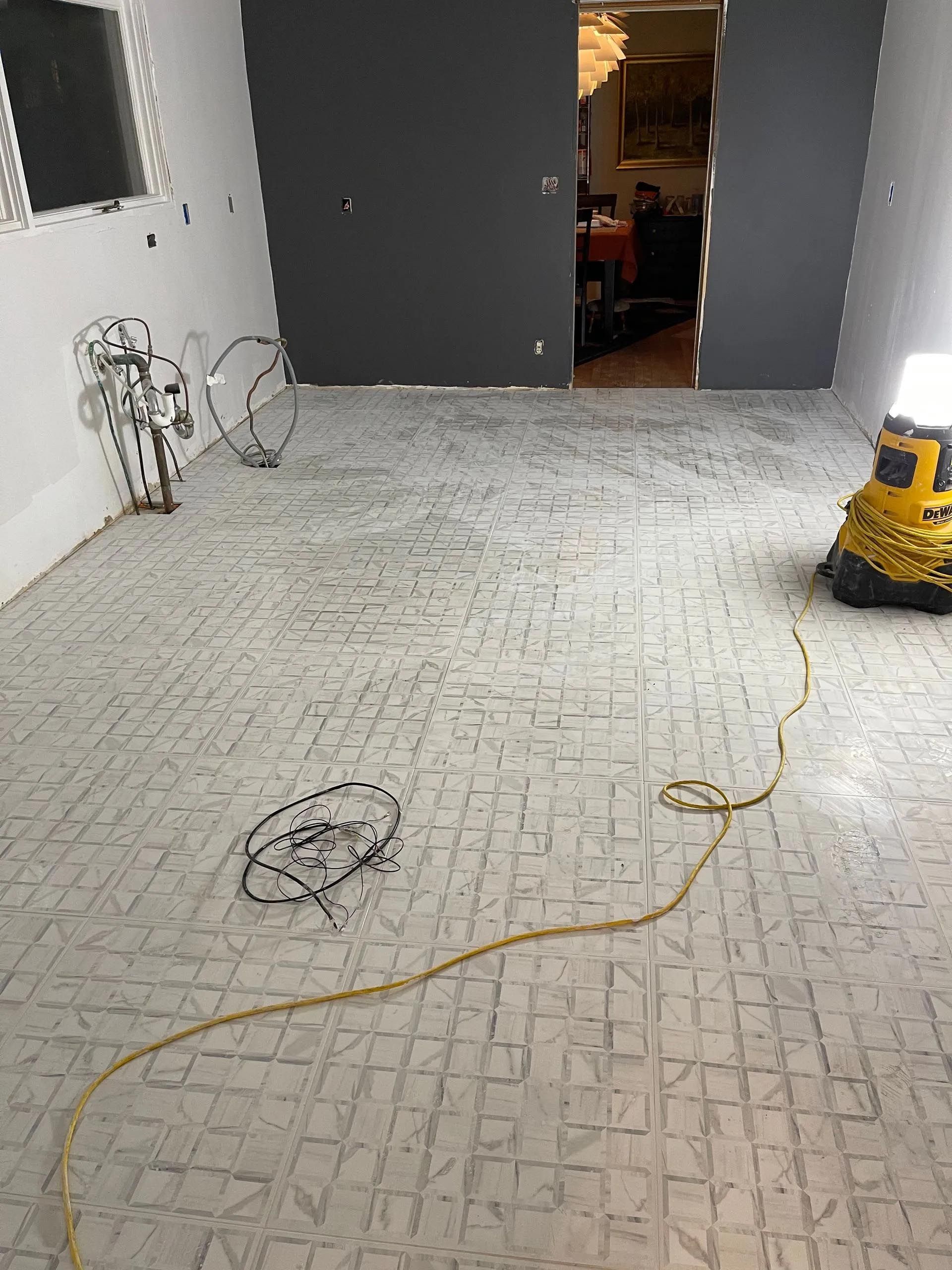 A room with a brick floor and a yellow vacuum cleaner.