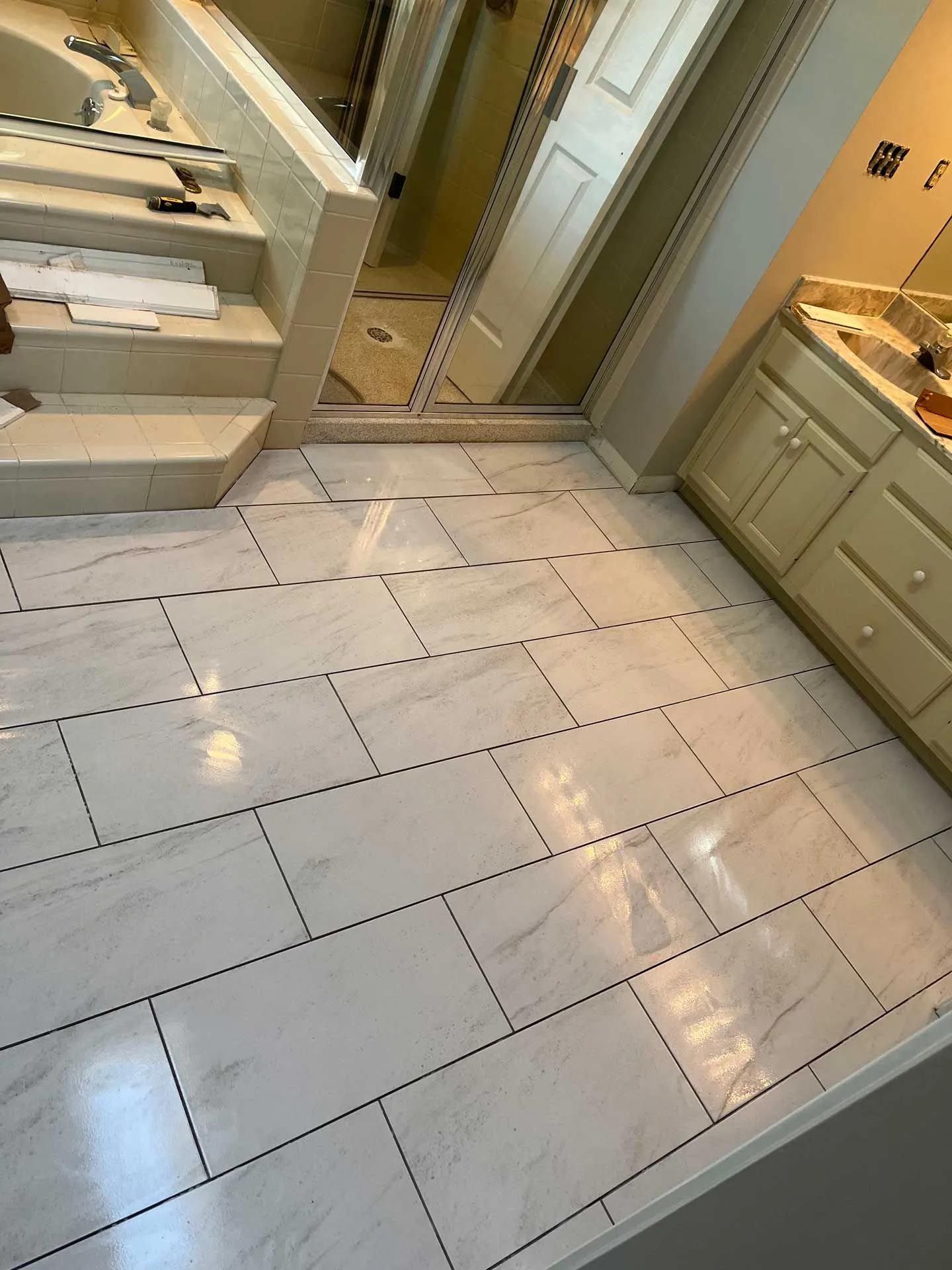 A bathroom with white tile floors and white cabinets.