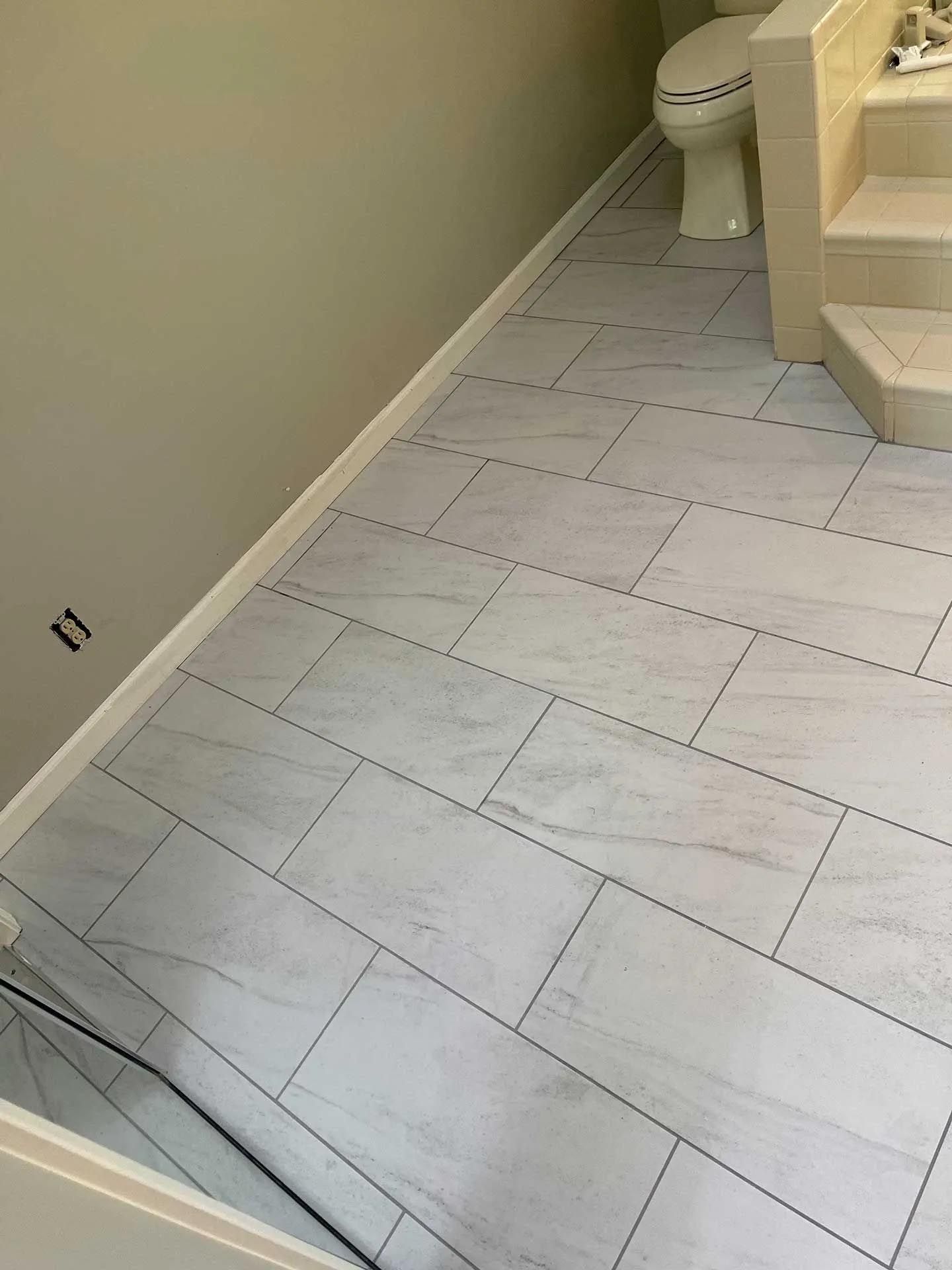 A bathroom with white tile floors and a toilet.