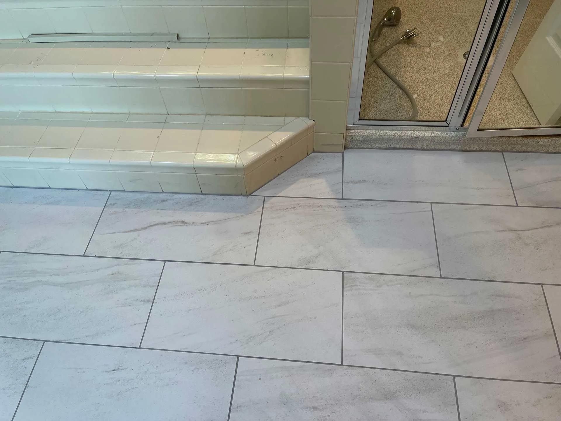 A bathroom with white tile floors and stairs