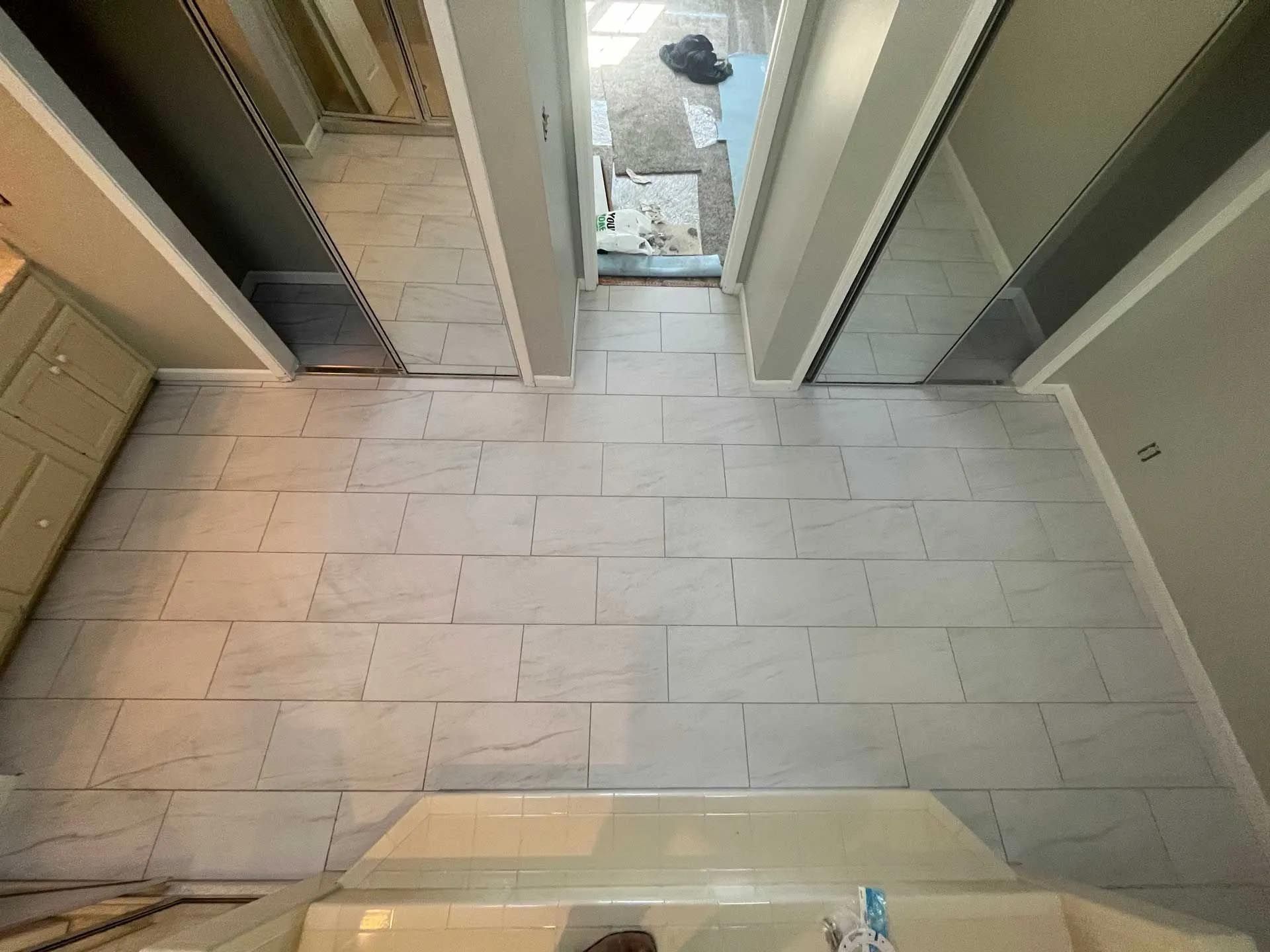 An aerial view of a bathroom with tile floors and a bathtub.