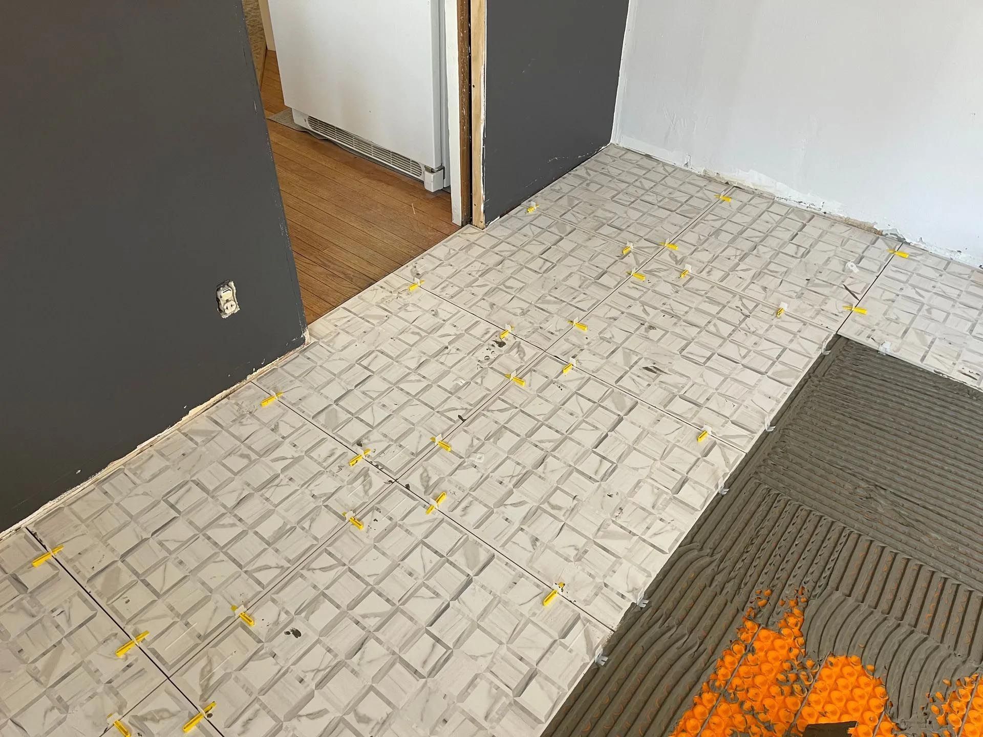 A tile floor is being installed in a room.