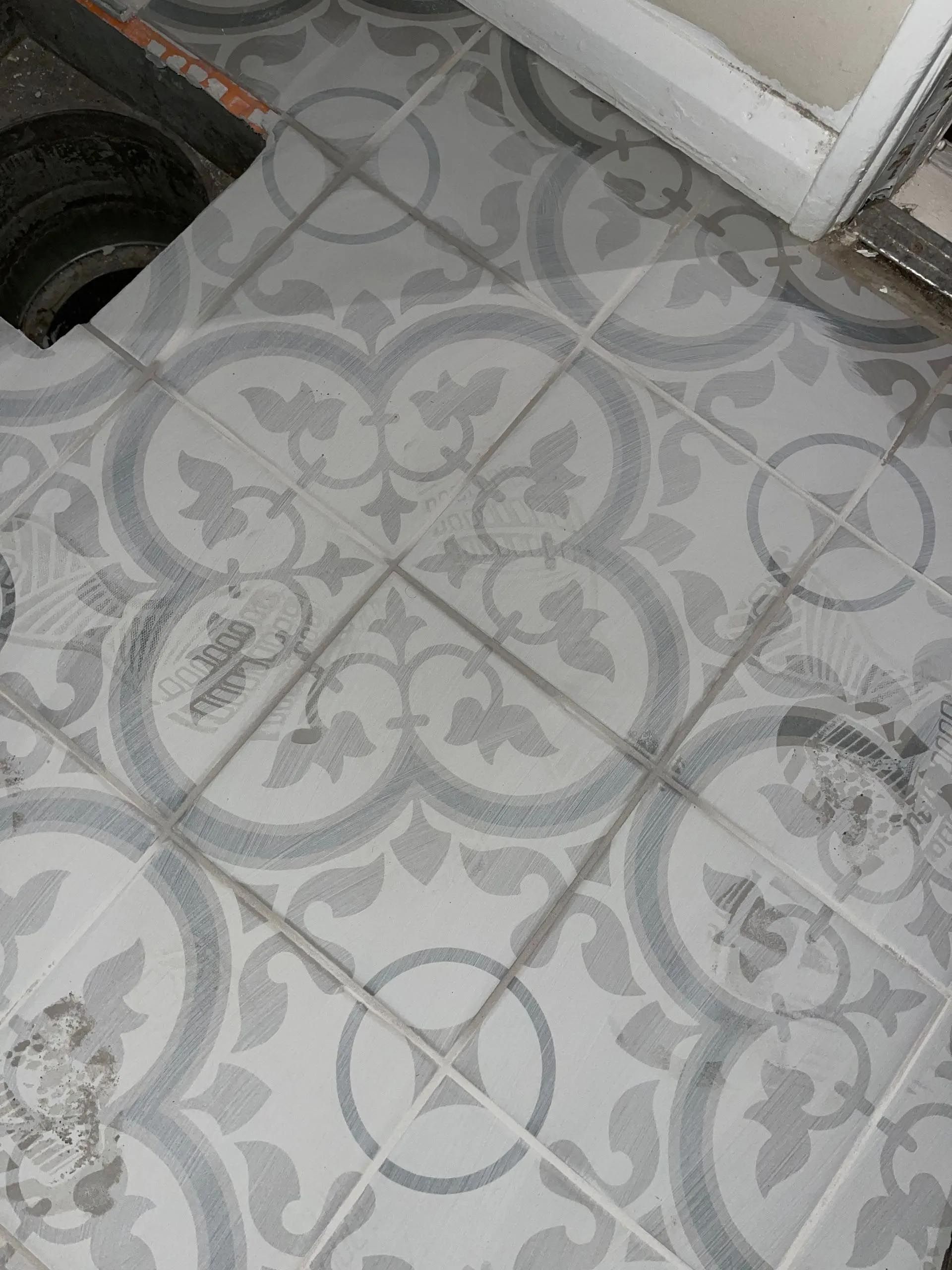 A close up of a tiled floor with a pattern on it.
