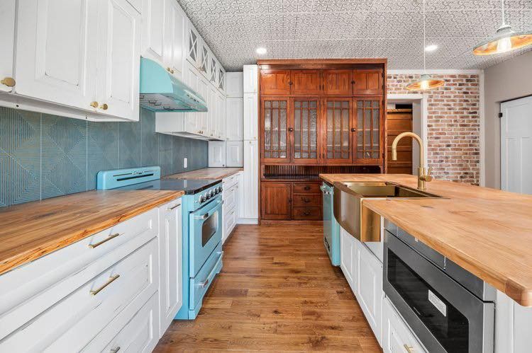 A kitchen with wooden cabinets and a laptop on the counter.
