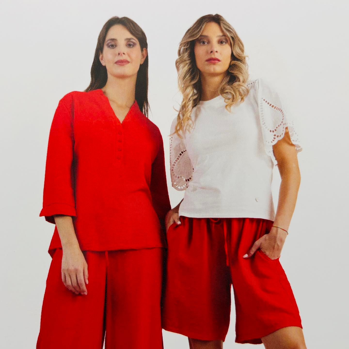 Due donne in piedi una accanto all'altra che indossano camicie e pantaloncini rossi