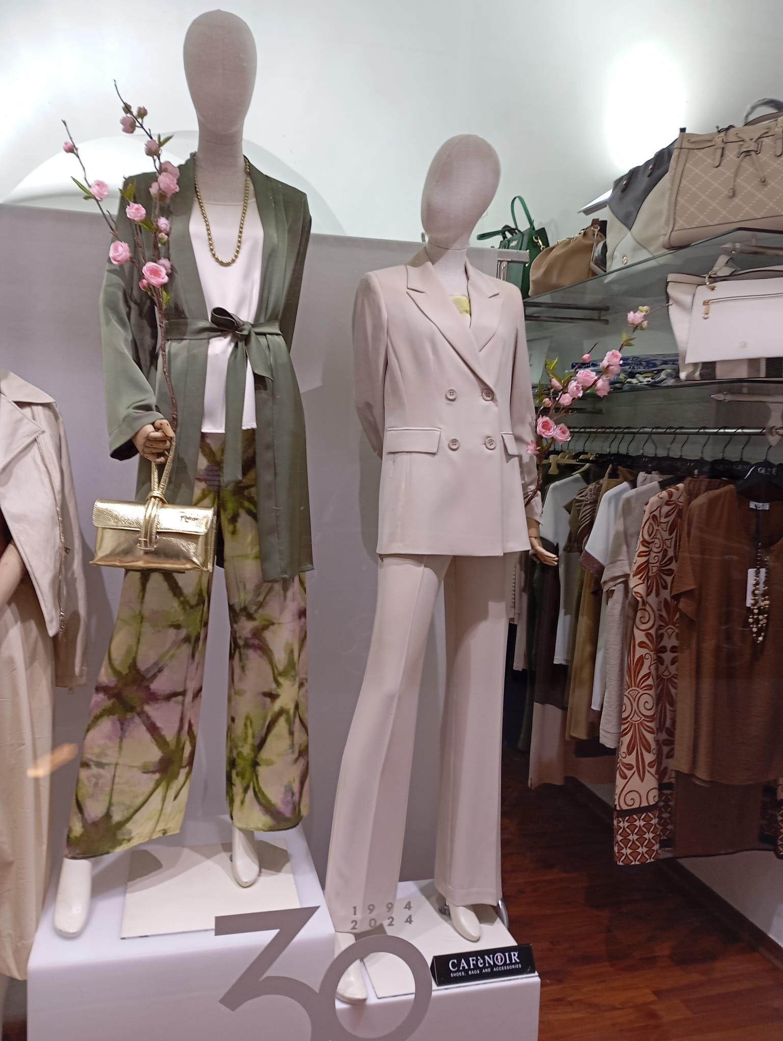 Un manichino indossa un abito bianco e una giacca verde