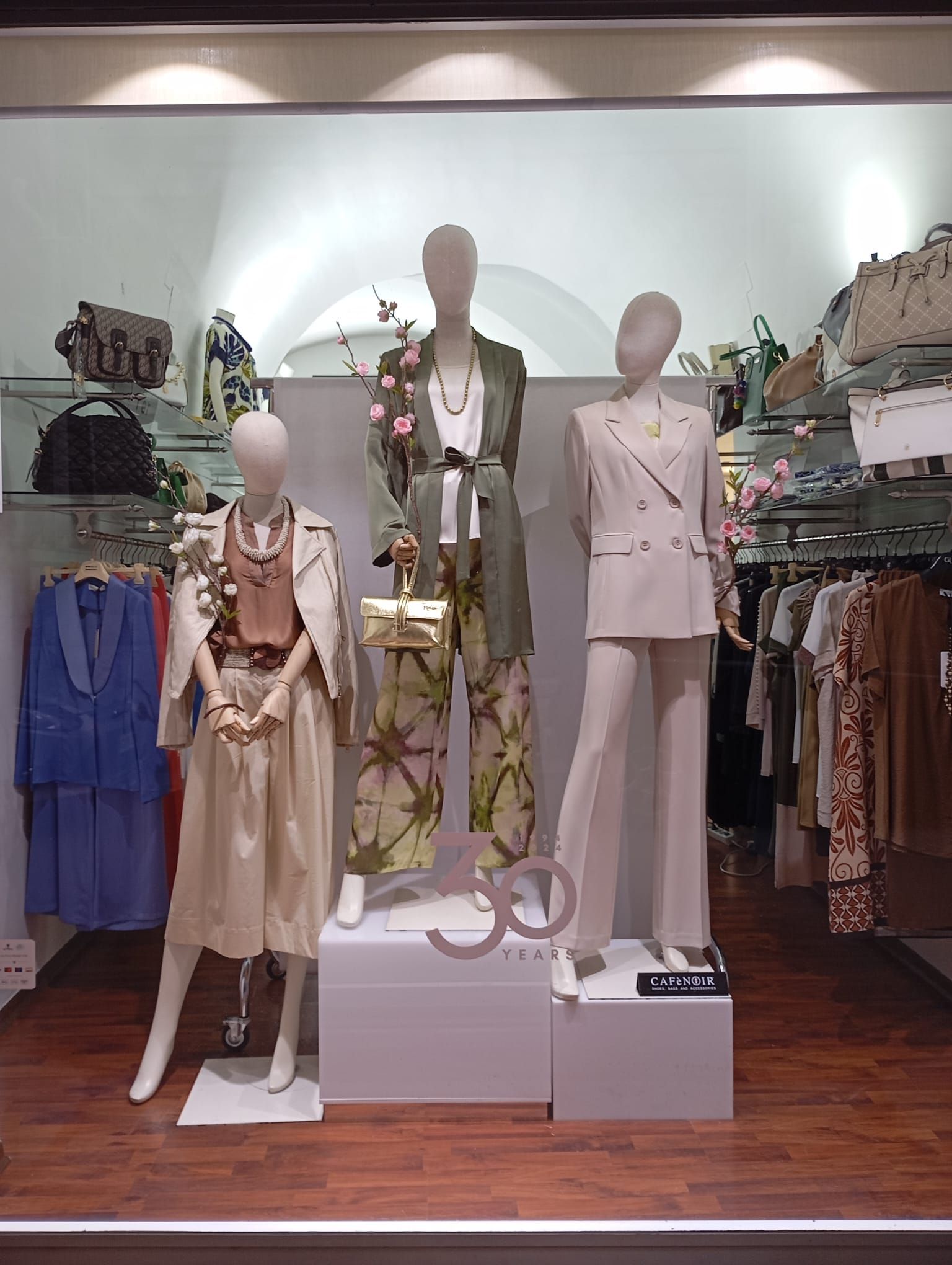 Tre manichini sono esposti nella vetrina di un negozio.