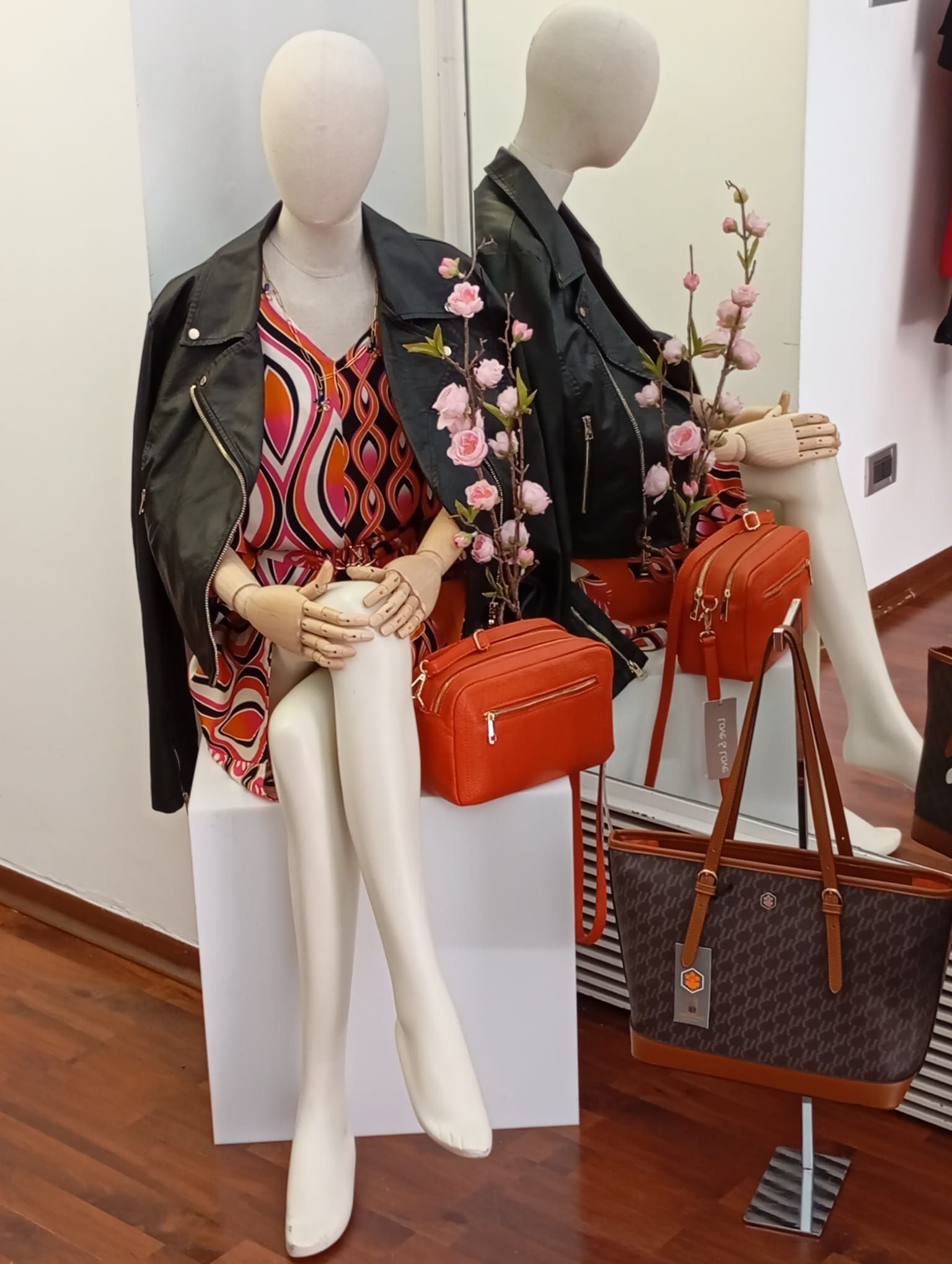 Un manichino è seduto su una scatola davanti a uno specchio.