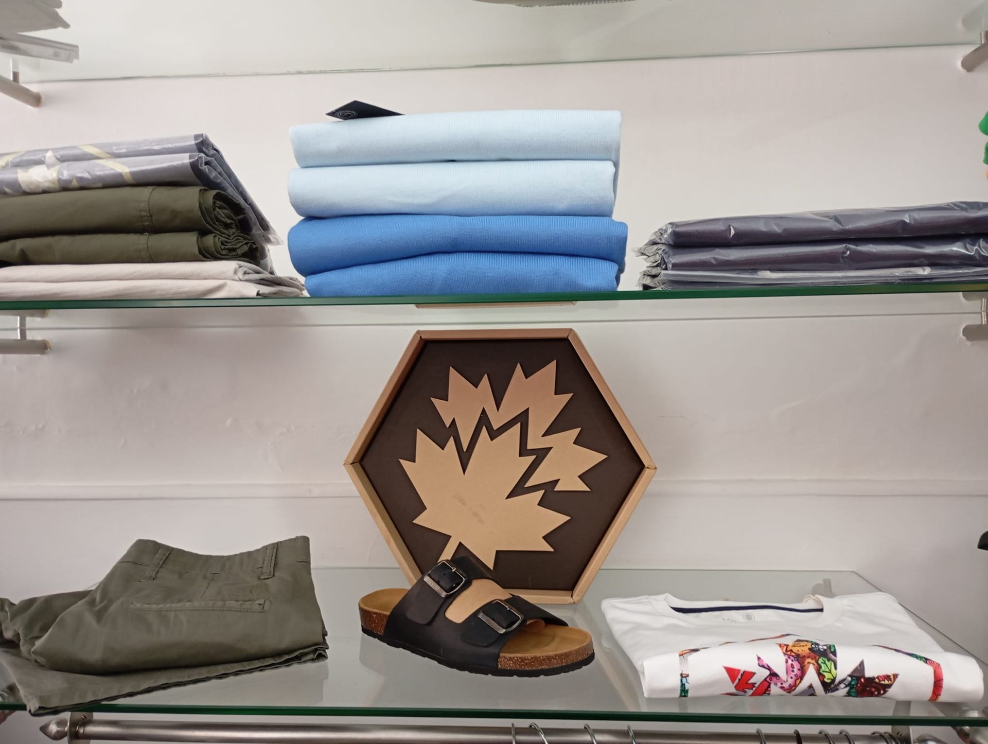 Un'immagine di una foglia d'acero su uno scaffale accanto a un paio di sandali