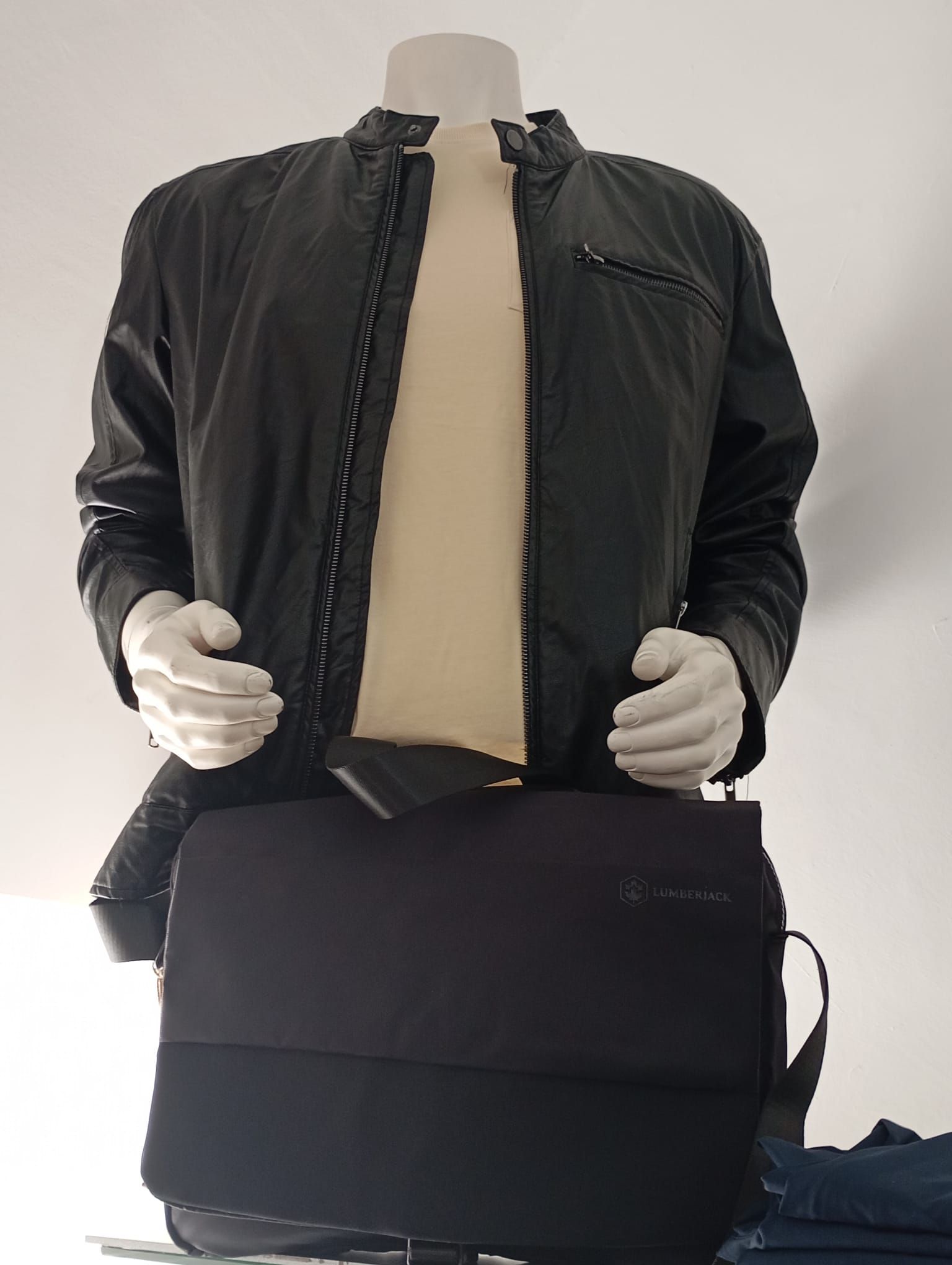 Un manichino che indossa una giacca nera e una borsa a tracolla nera