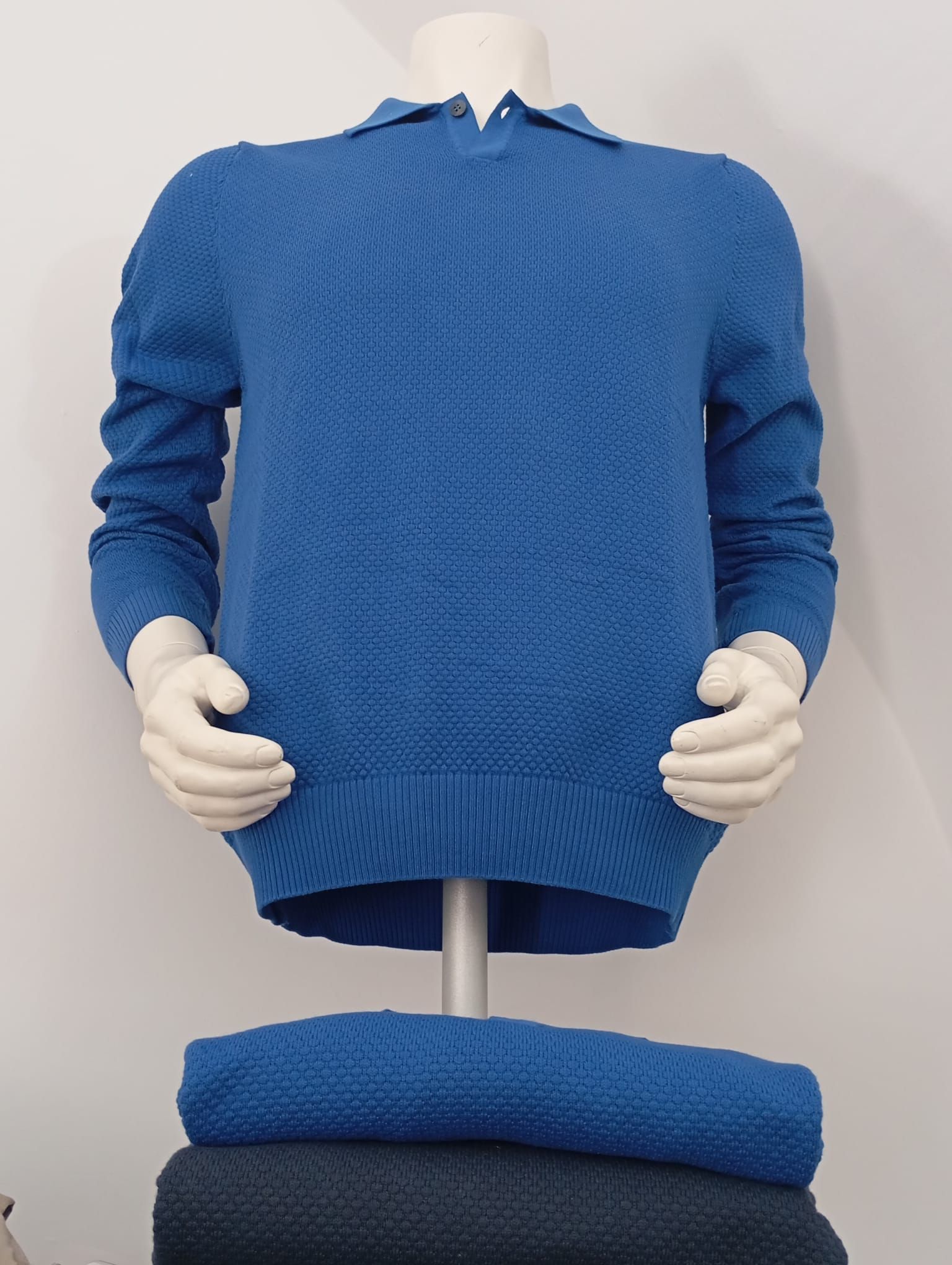 Un manichino indossa un maglione blu con colletto