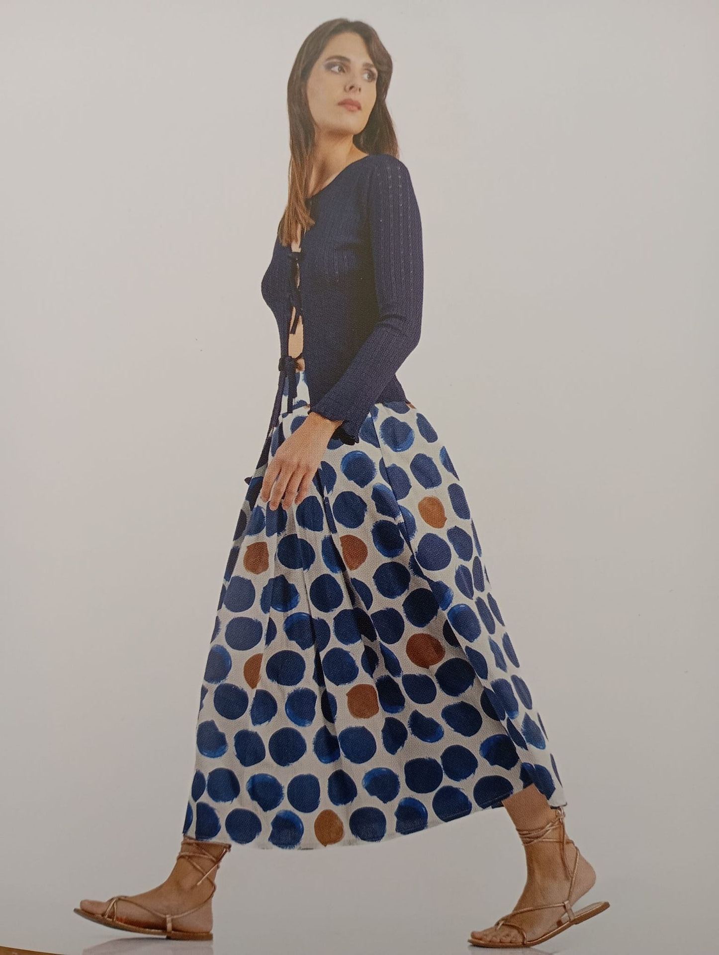 Una donna che indossa un top blu e una gonna a pois blu e bianchi