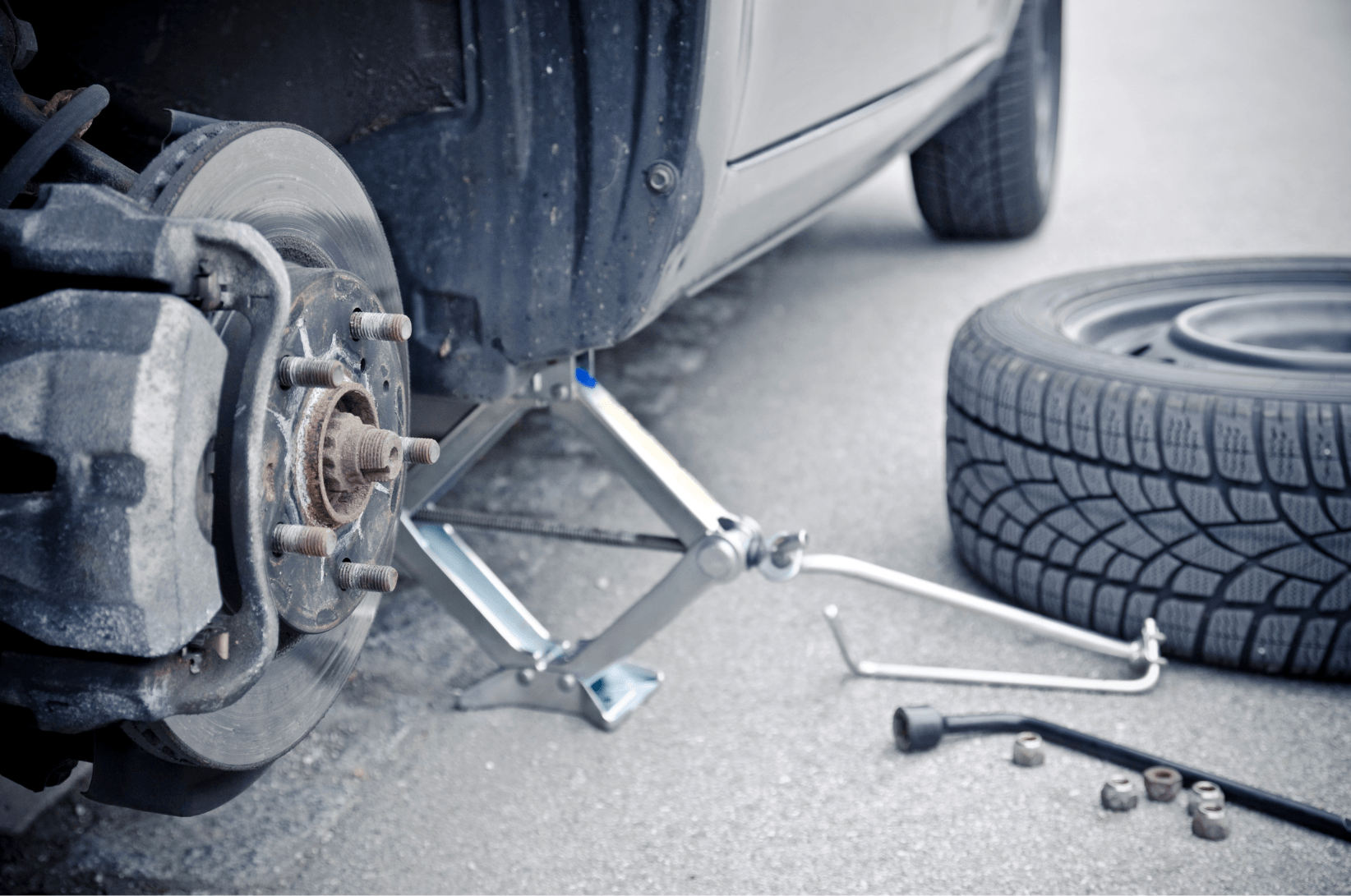 Tire repair on the side of the road with a tire jack