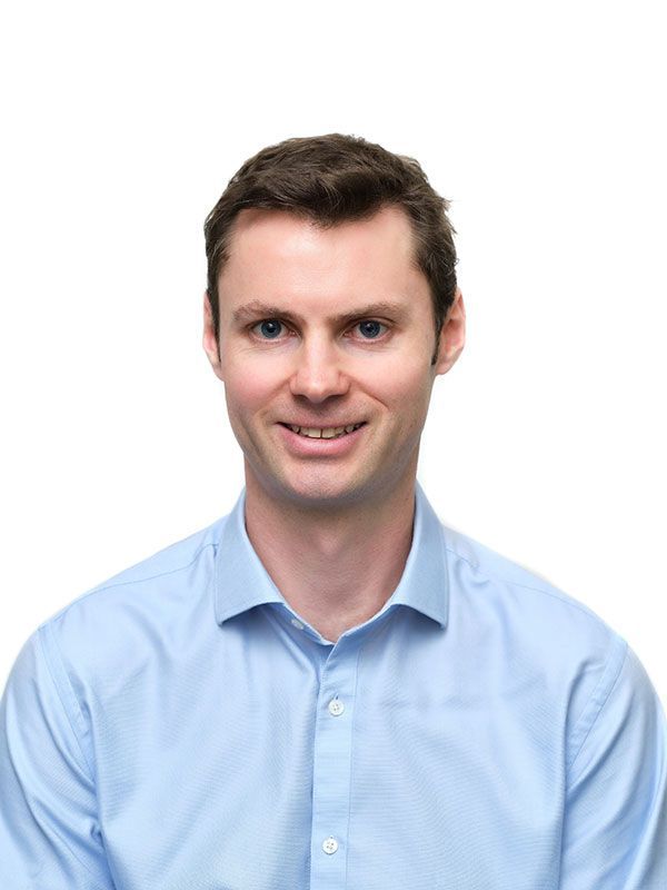 A man in a blue shirt is smiling for the camera.