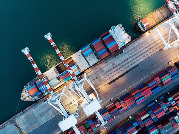 An aerial view of a large container ship docked in a harbor.