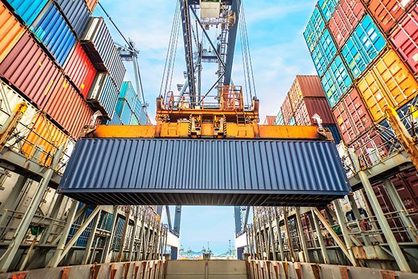 A large container is being loaded onto a cargo ship.